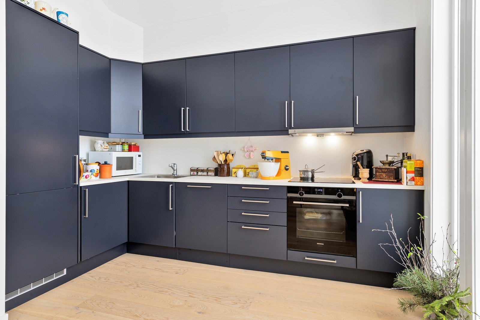 Kvalitetskjøkken fra Sigdal i en trendy mørk moderne blåtone med integrerte hvitevarer (oppvaskmaskin, stekovn og koketopp) fra Simens. Galleribilde