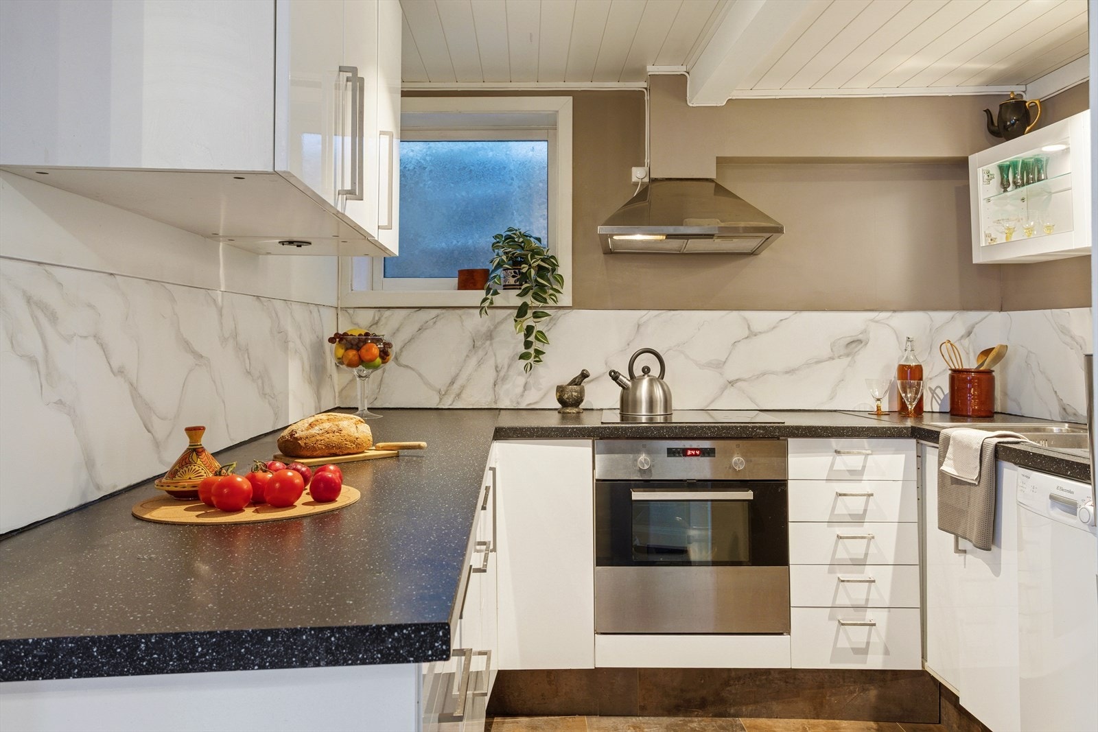 Det lille kjøkkenet har overraskende god benkeplass - her er det enkelt å holde orden og lage mat med stil. Galleribilde