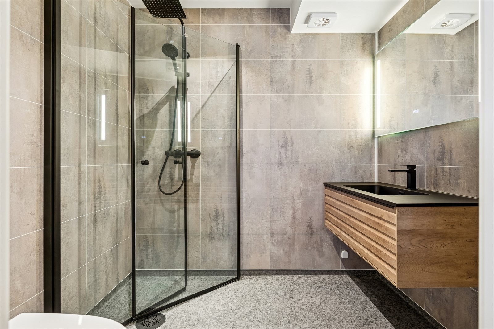 Lekkert bad med baderomsplater på vegger og vinylbelegg på gulv med gulvvarme. Galleribilde