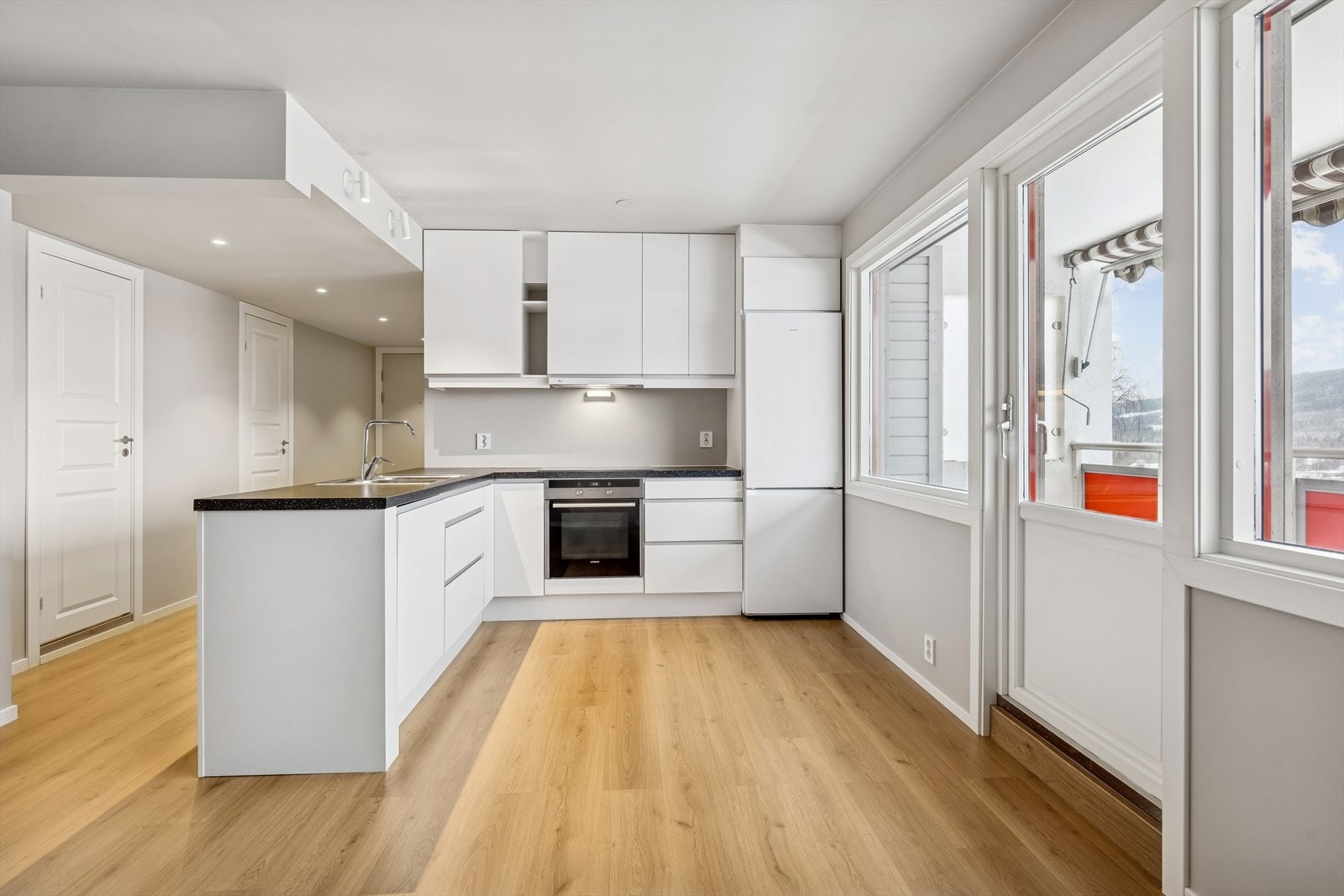 Lyst og trivelig kjøkken med åpen løsning til stue og utgang til balkong. Galleribilde