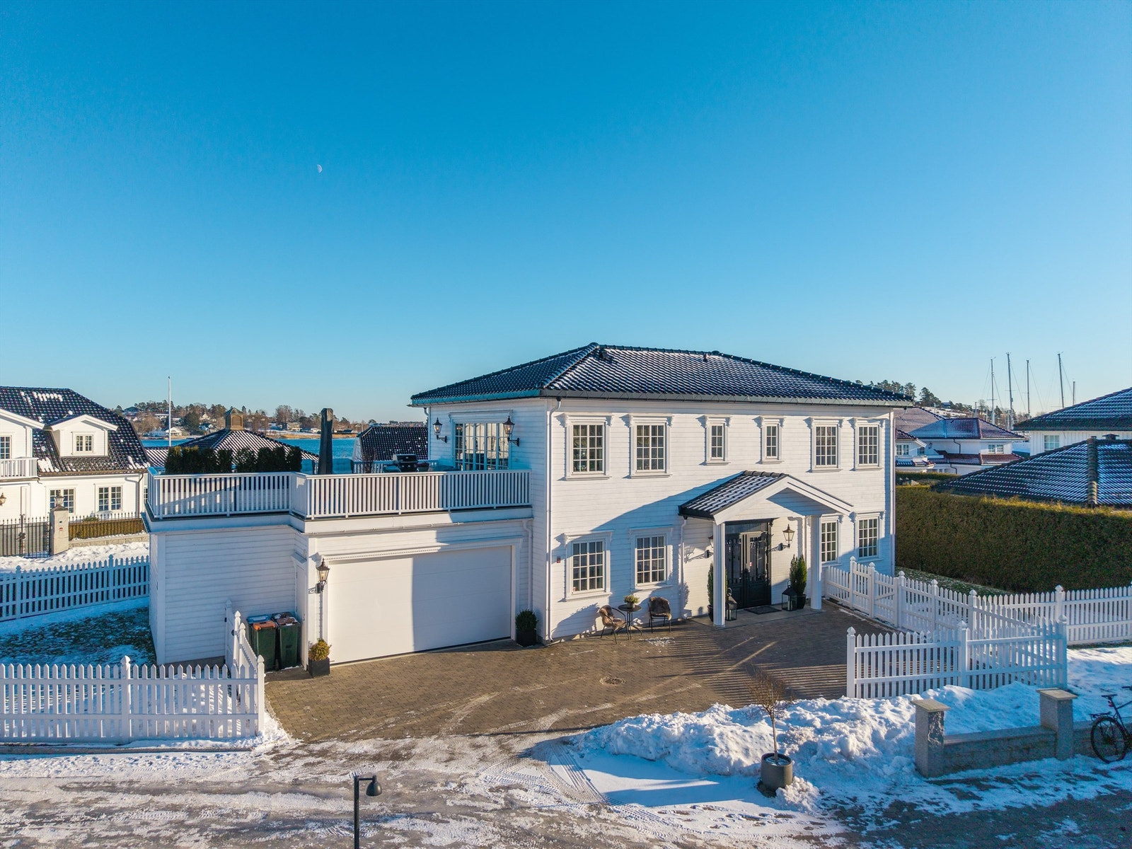 Den flotte villaen er omgitt av gressplen, med hekk mot veien og en romslig gårdsplass ved inngangspartiet. Galleribilde