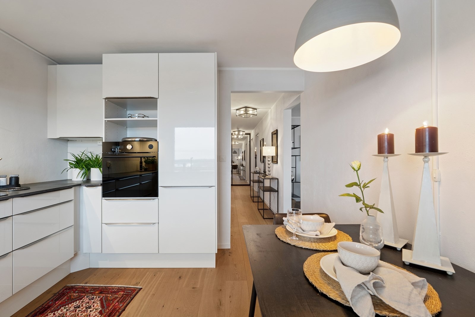 Enestående kjøkken fra NOREMA med eksklusive hvitevarer - dør til kjøkken og stue er fjernet og gulvet er gjennomgående mellom gang, stue og kjøkken Galleribilde