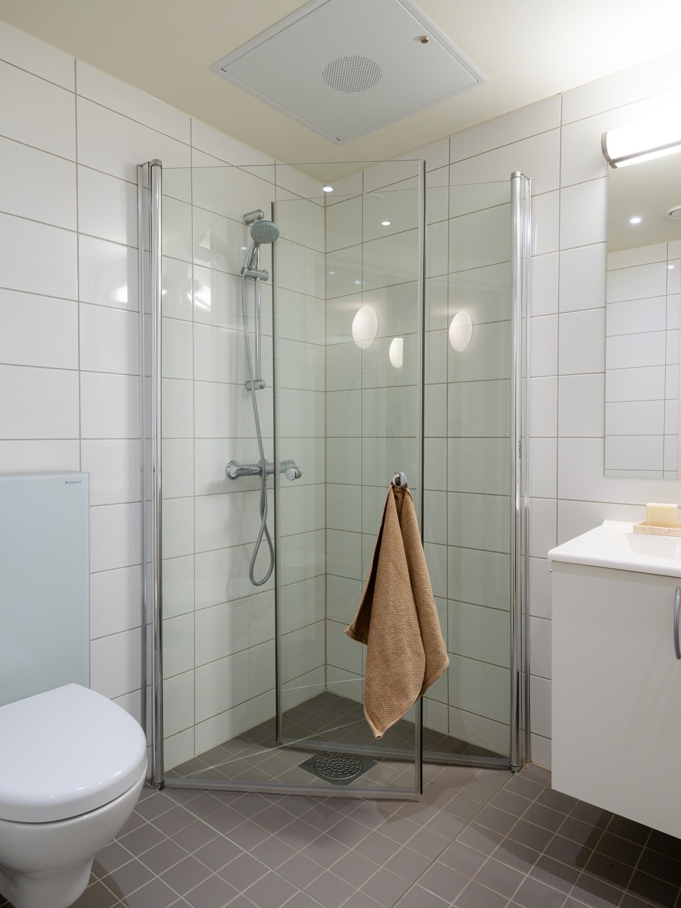 Innredningen består av servant på underskap, speil, vegghengt toalett og dusjhjørne. Galleribilde