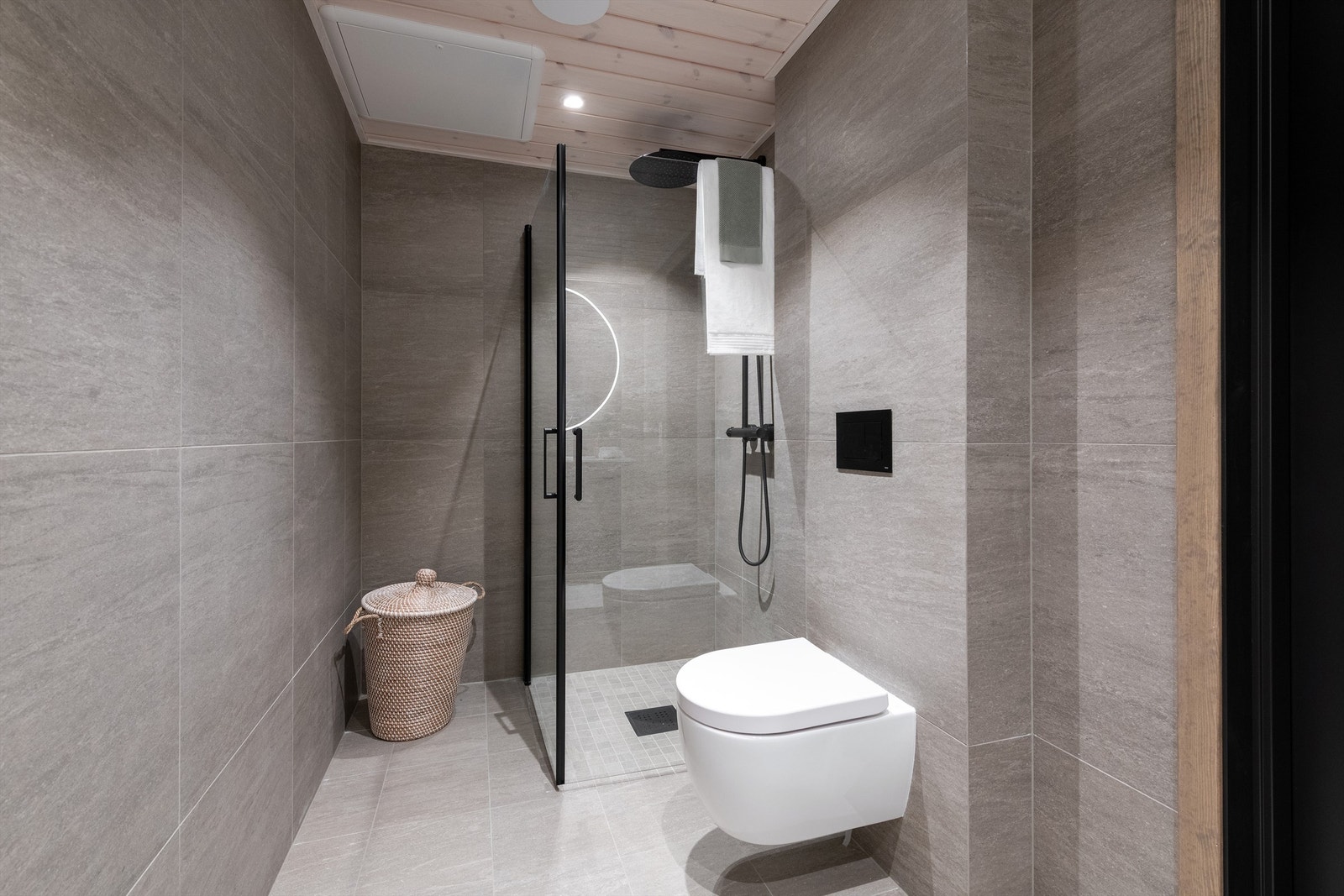 Hovedbad med dusjhjørne med dører og vegghengt dusjarmatur med hånddusj og regndusj. Vegghengt toalett Galleribilde