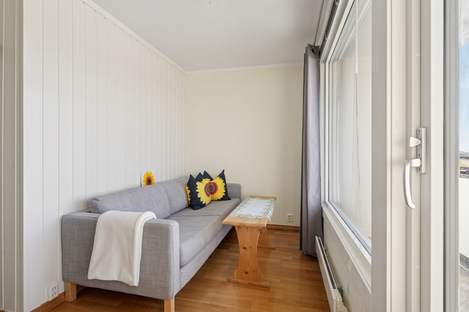 Her er det plass til en komfortabel sofa og et lite bord, og rommets lyse flater og store vinduer skaper en lun og behagelig atmosfære. Galleribilde