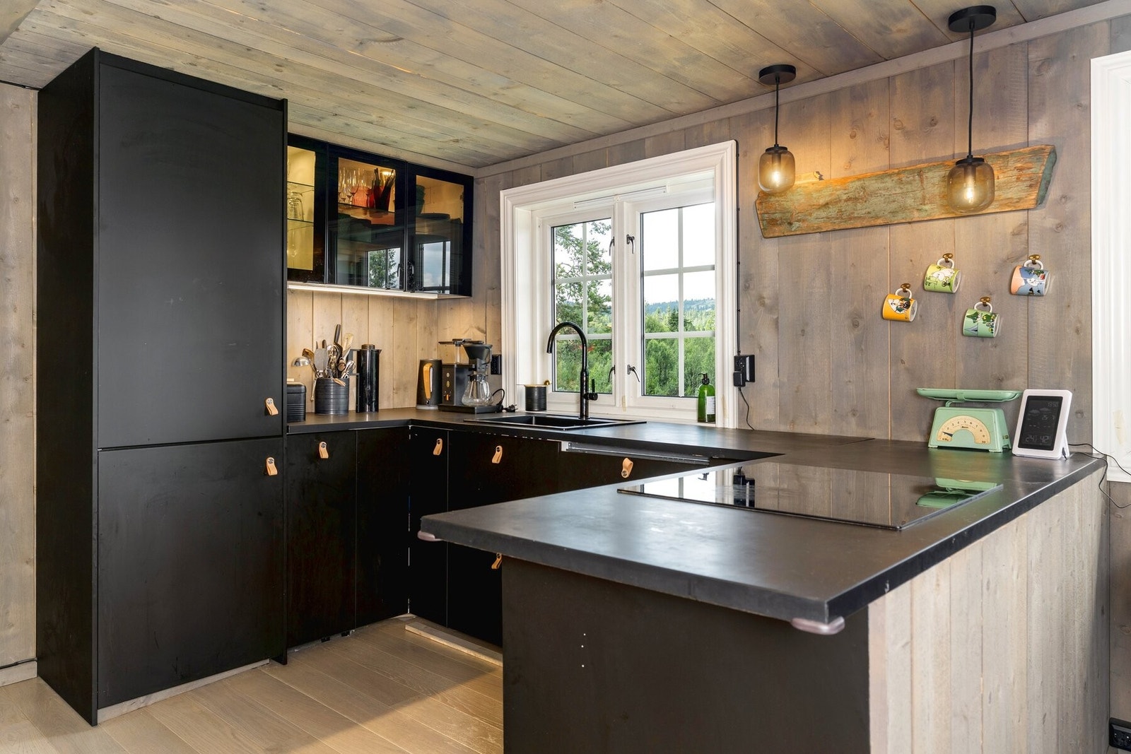 Kjøkkeninnredning med slette lakkerte fronter, laminat benkeplate og integrert platetopp, stekeovn, oppvaskmaskin og kjøl/ fryseskap. Galleribilde