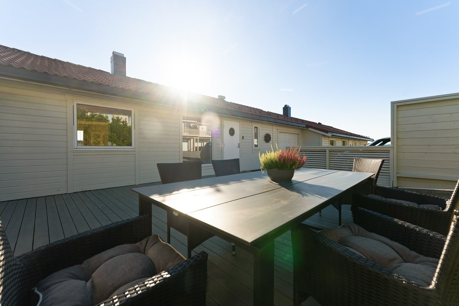 Nyt solrike dager på denne romslige terrassen like ved inngangspartiet. Perfekt for sosiale sammenkomster og avslapning i rolige omgivelser. Galleribilde