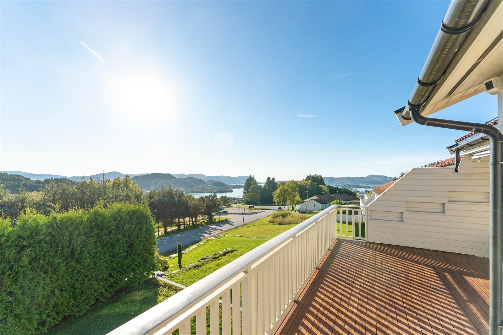 Strålande utsikt over naturskjønt landskap med sjø og fjell. Solrik balkong for avslapning og nytelse av vakre omgivelser. Galleribilde