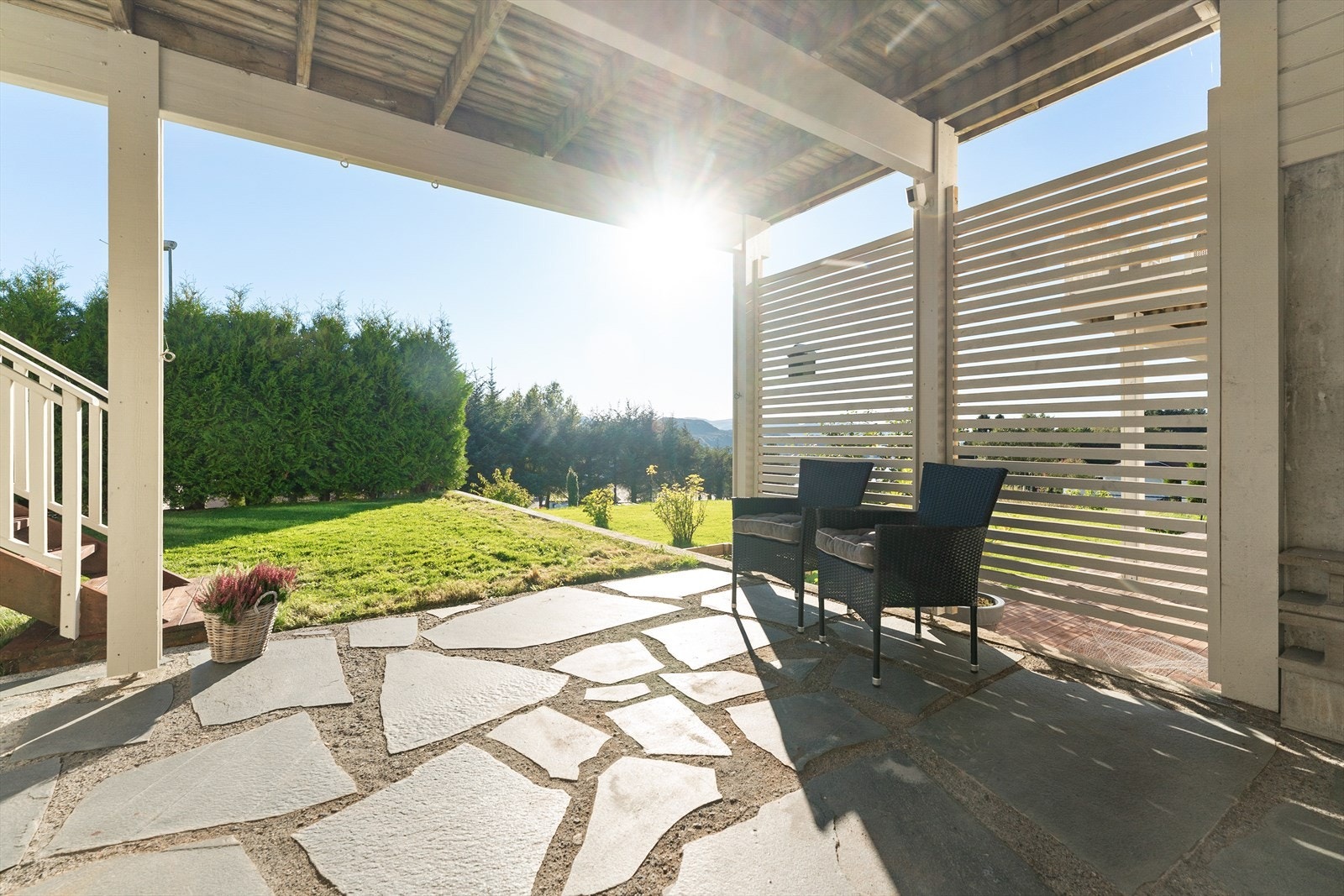 Solrik uteplass med moderne pergola, flott steinlegging og naturskjønn utsikt. Perfekt for avslapning og sosiale sammenkomster. Galleribilde