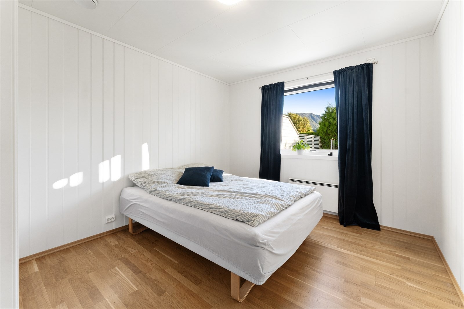 Lyst soverom med store vinduer gir naturlig lys og vakker utsikt mot fjellene. Galleribilde