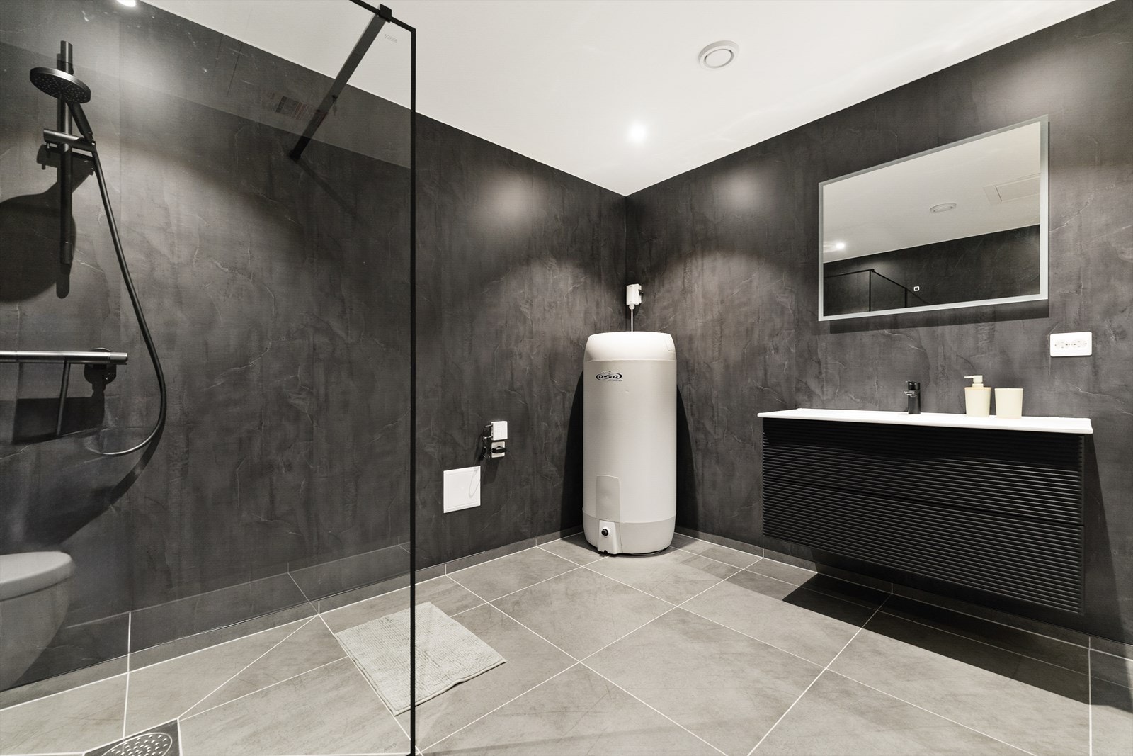 Badet er utstyrt med baderomsinnredning, vegghengt wc og dusjvegger. Galleribilde