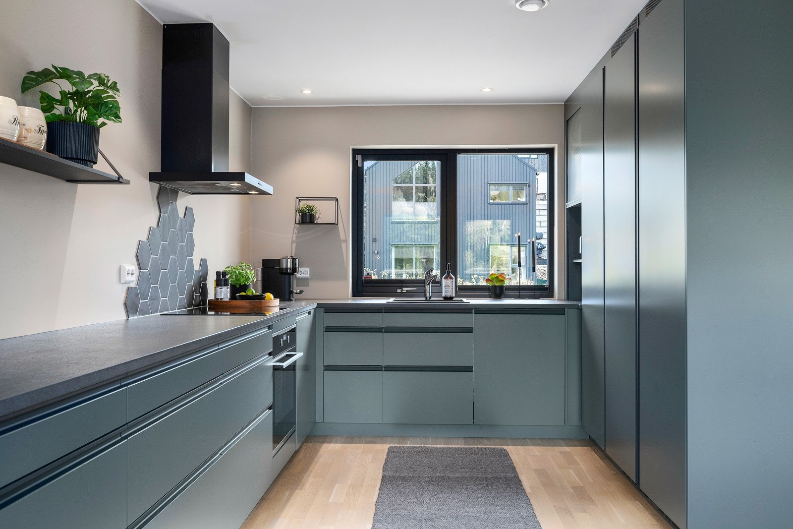 Kjøkkenet har moderne innredning med slette fronter, laminat benkeplate og helintegrerte hvitevarer. Galleribilde