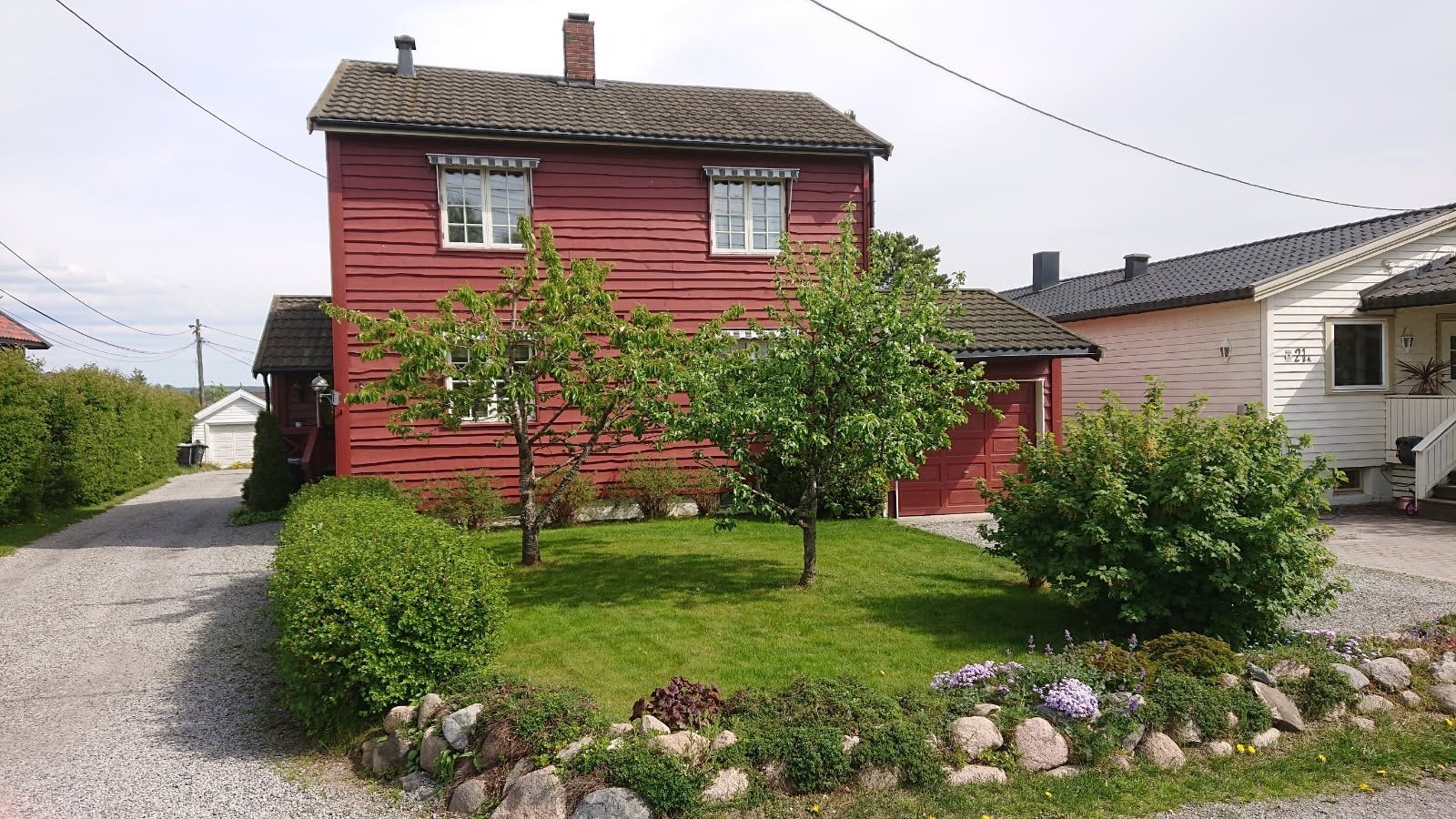 Hagedelen er pent opparbeidet med plen, prydbusker, morelltre- og epletrær, blomsterbed med variert beplantning m.m. Galleribilde