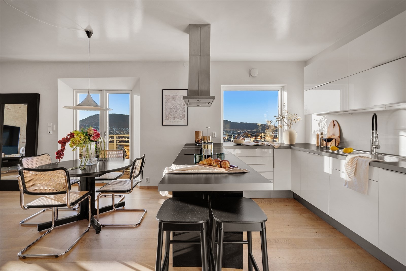 Ikea kjøkkeninnredning med hvite høyglansfronter og laminat benkeplate med vaskekum og benkebeslag. Galleribilde