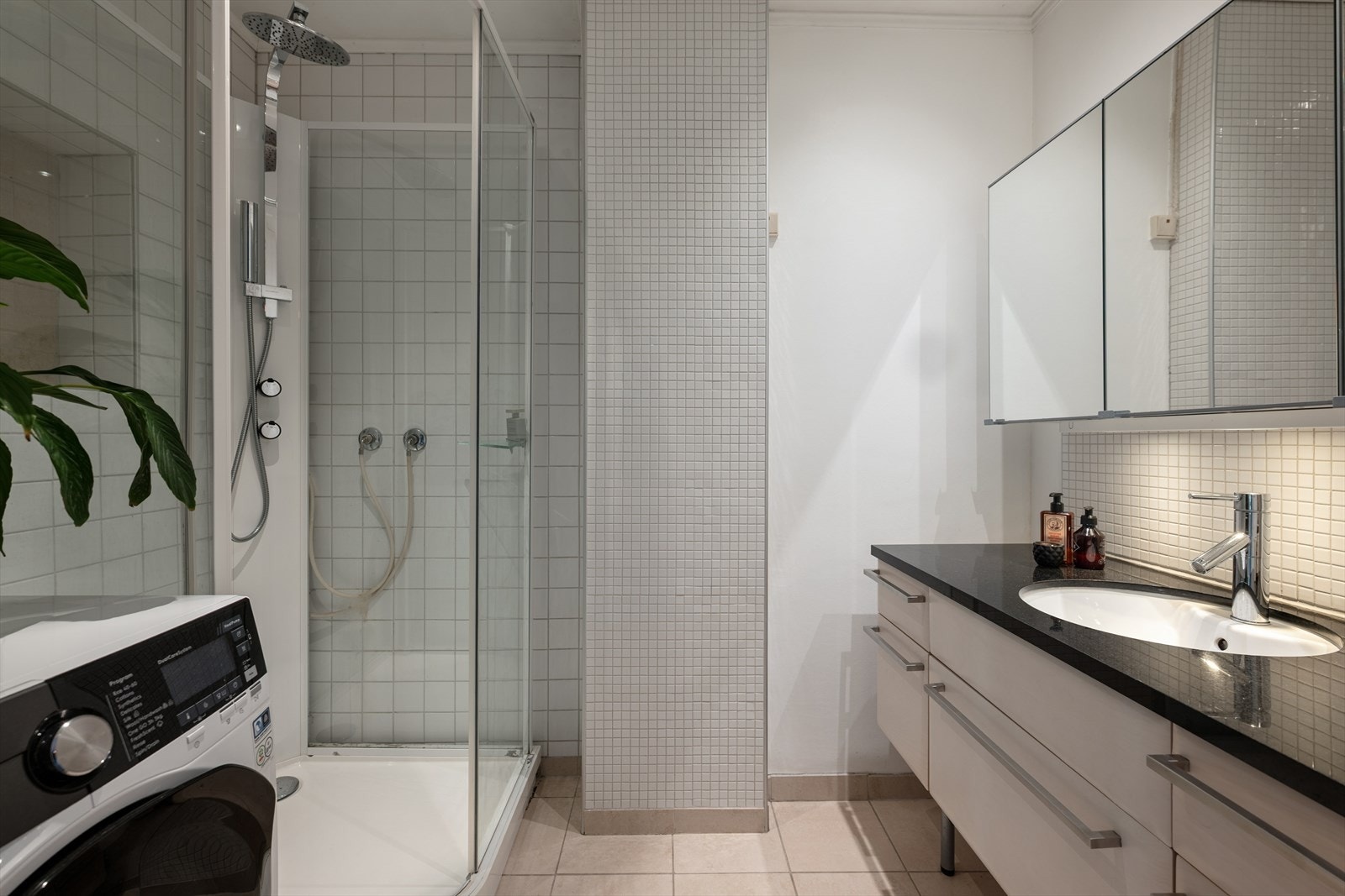 Det delvis flislagte badet fremstår moderne, med stilren baderomsinnredning og god funksjonalitet. Dusjkabinettet er et praktisk valg som både beskytter flisene mot unødig slitasje og gjør rengjøringen enklere. Galleribilde