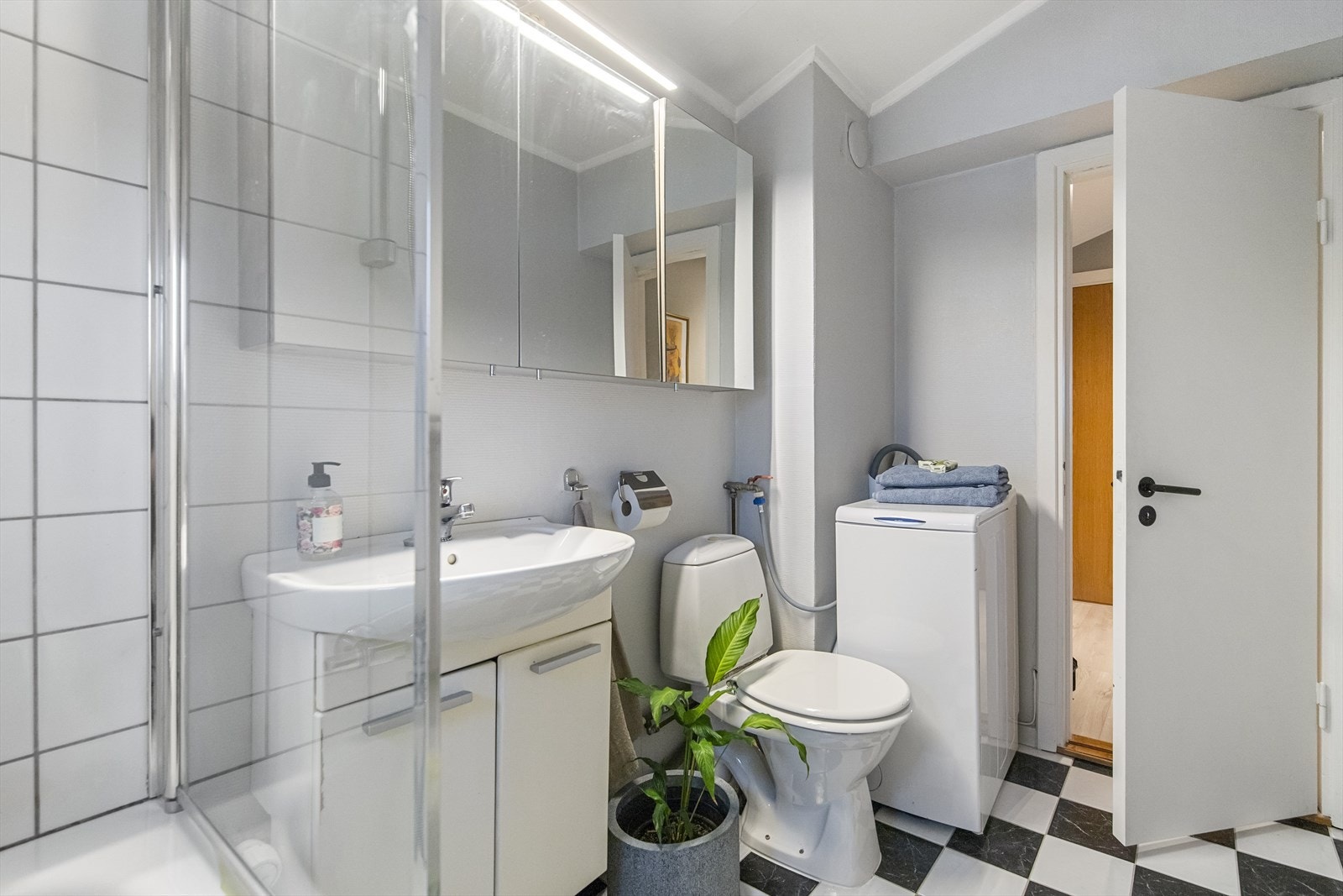 Badet har også servant i innredning og praktisk opplegg for vaskemaskin. Galleribilde