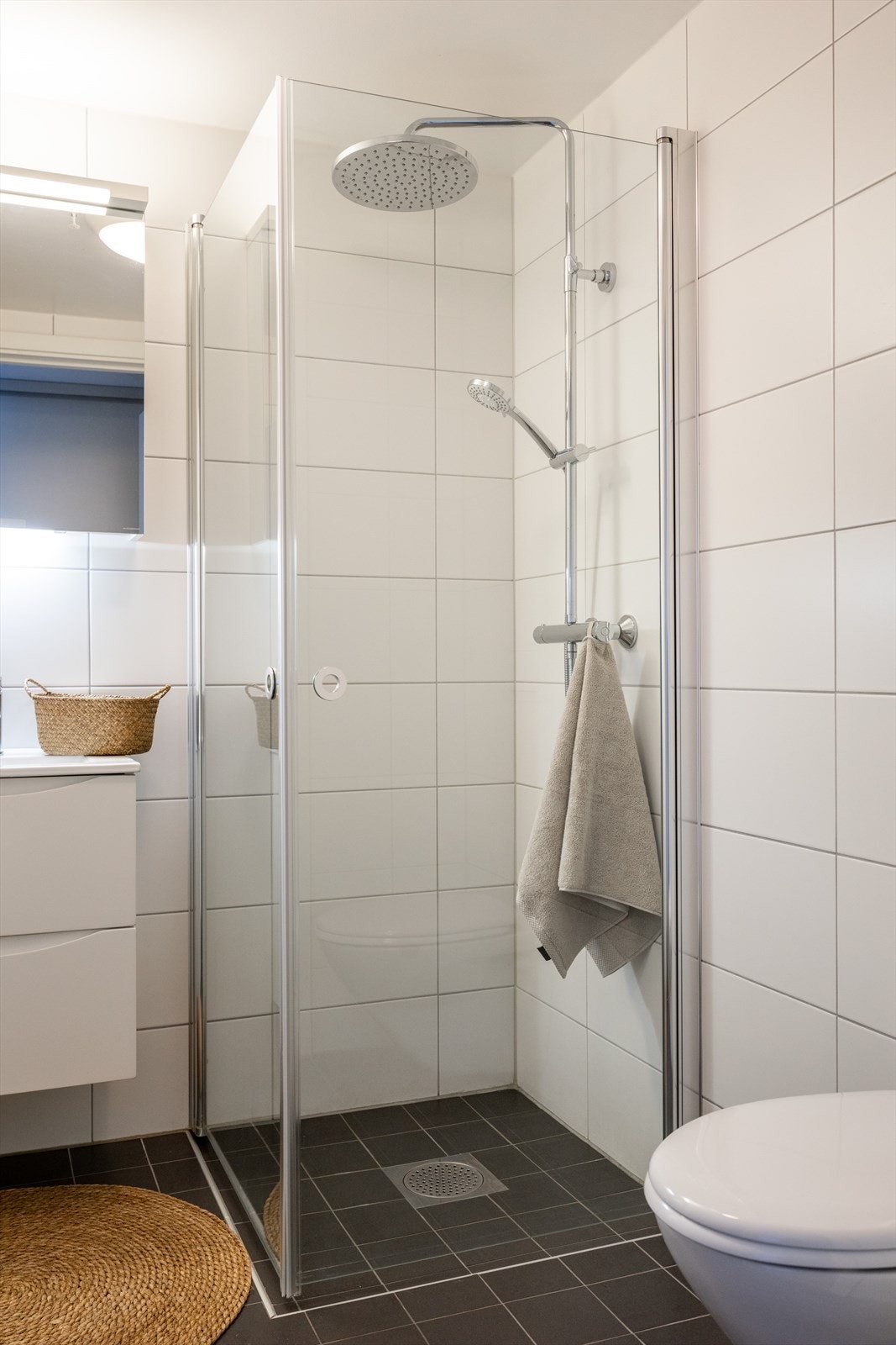 Badet er innredet med vegghengt klosett, baderomsinnredning med heldekkende servant, speilskap og dusjvegger. Galleribilde