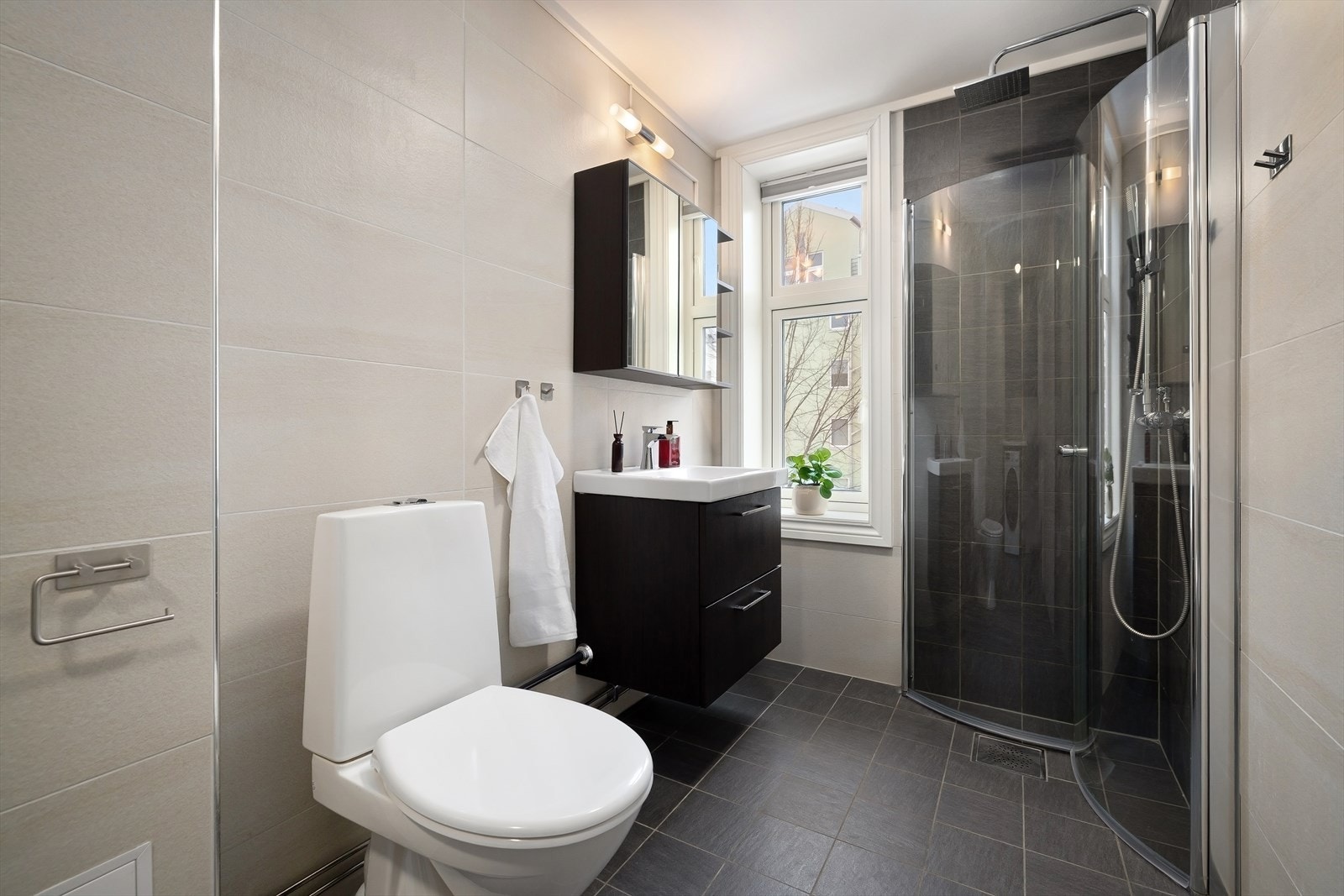 Leilighetens bad er fra 2015 og er helfliset og innredet i tidløs stil. Galleribilde