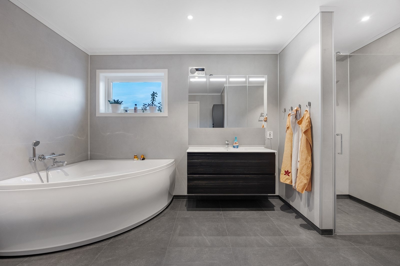 Badet har et stort dusjhjørne og et stort badekar. Galleribilde