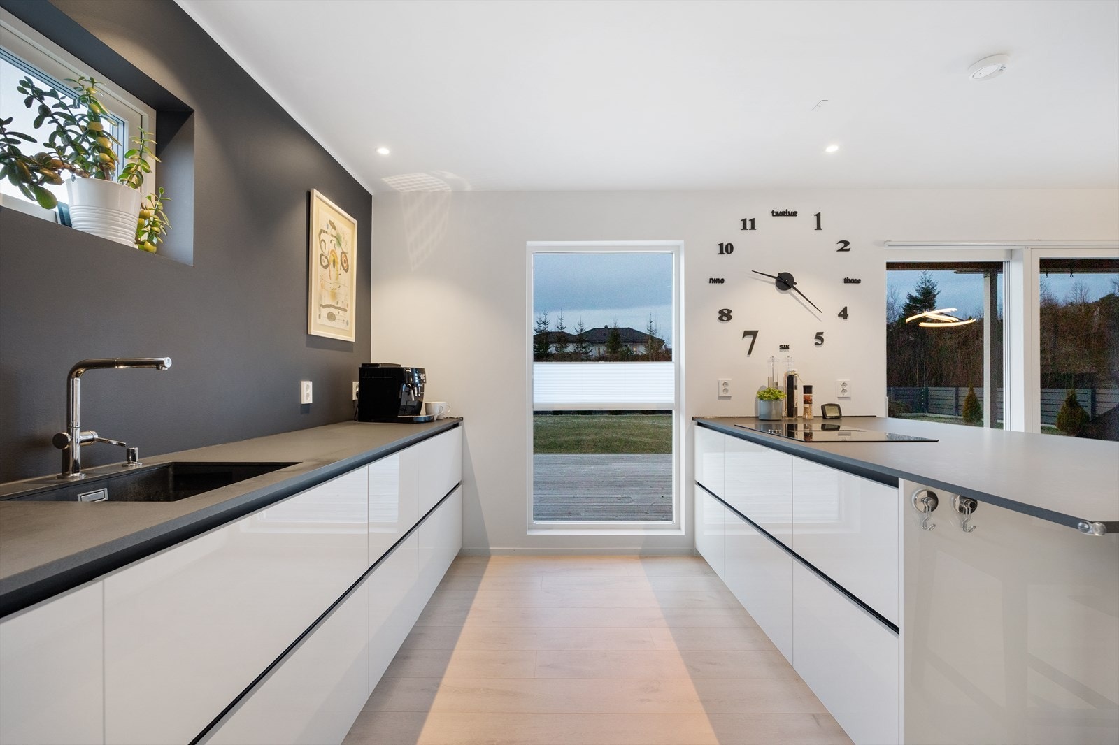 Kjøkkenet er stilfult med glatte fronter og en stor kjøkkenøy som deler stue og kjøkken naturlig inn i soner. Galleribilde