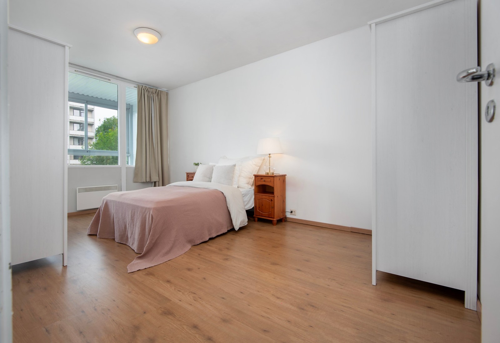 Hovedsoverommet i leiligheten er lyst og romslig. Det er god plass til dobbeltseng, nattbord - Galleribilde