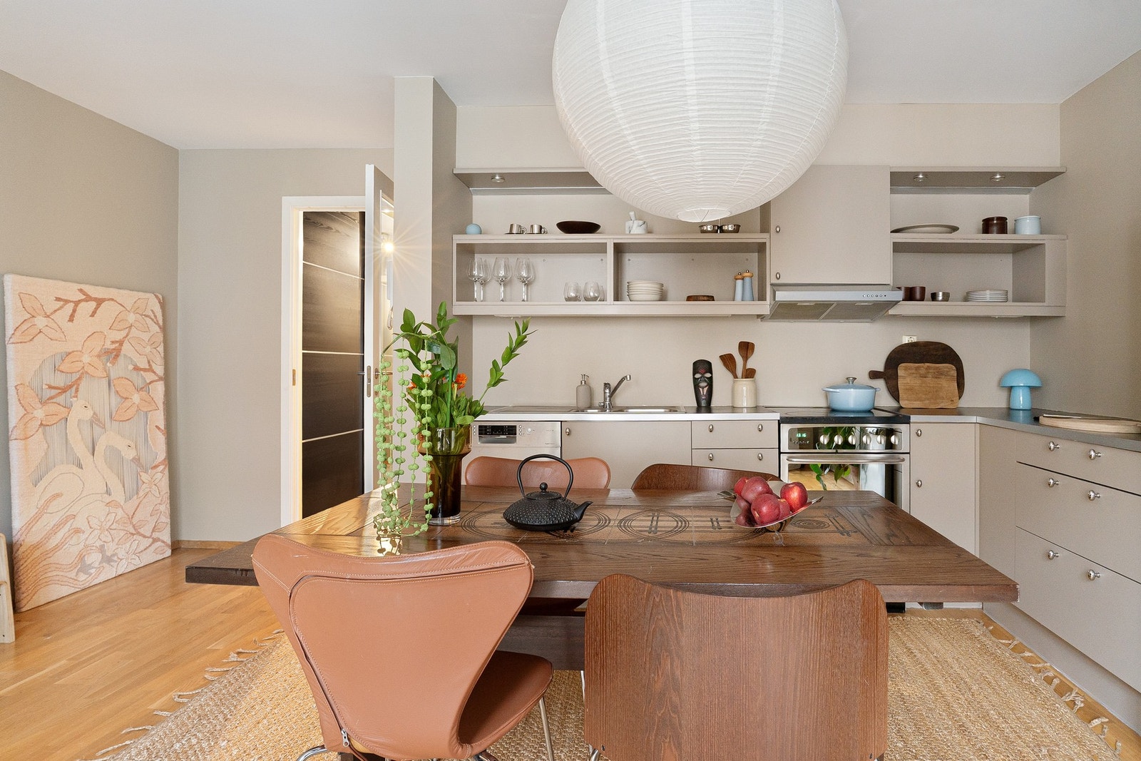 Kjøkkeninnredningen har glatte, lakkerte fronter og laminat benkeplate med nedfelt kum i rustfritt stål. Galleribilde