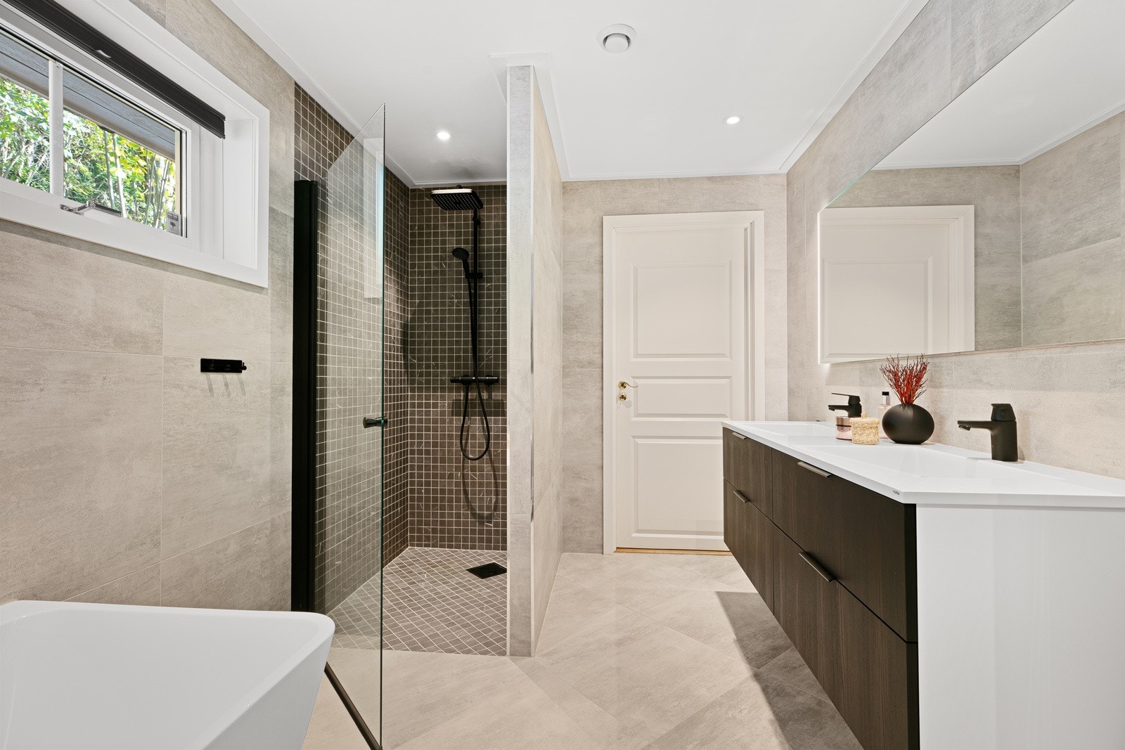 Badet har både badekar og romslig dusj Galleribilde