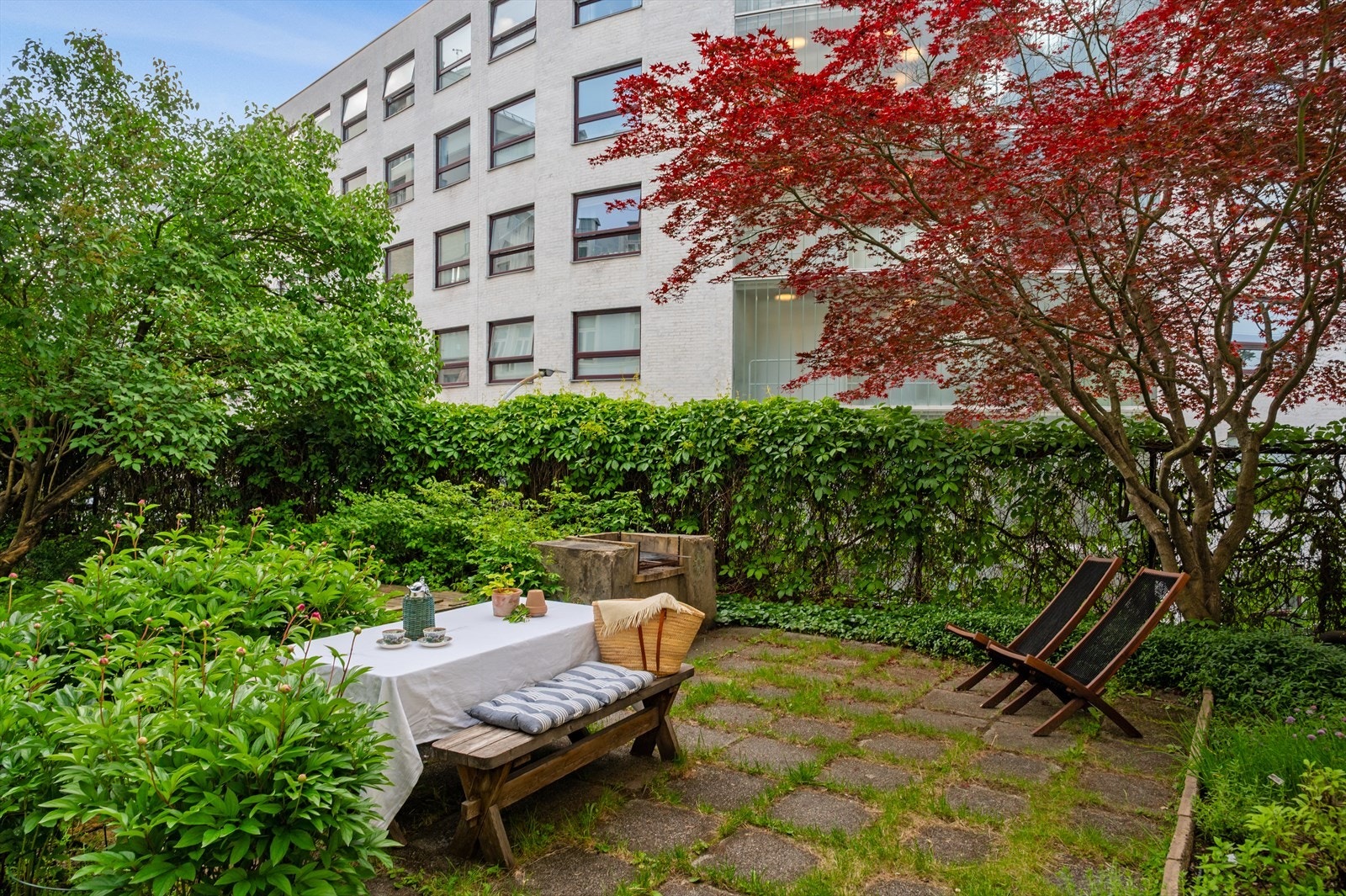 Pent opparbeidet bakgård med hyggelig sitteplass, beplantning og grill Galleribilde