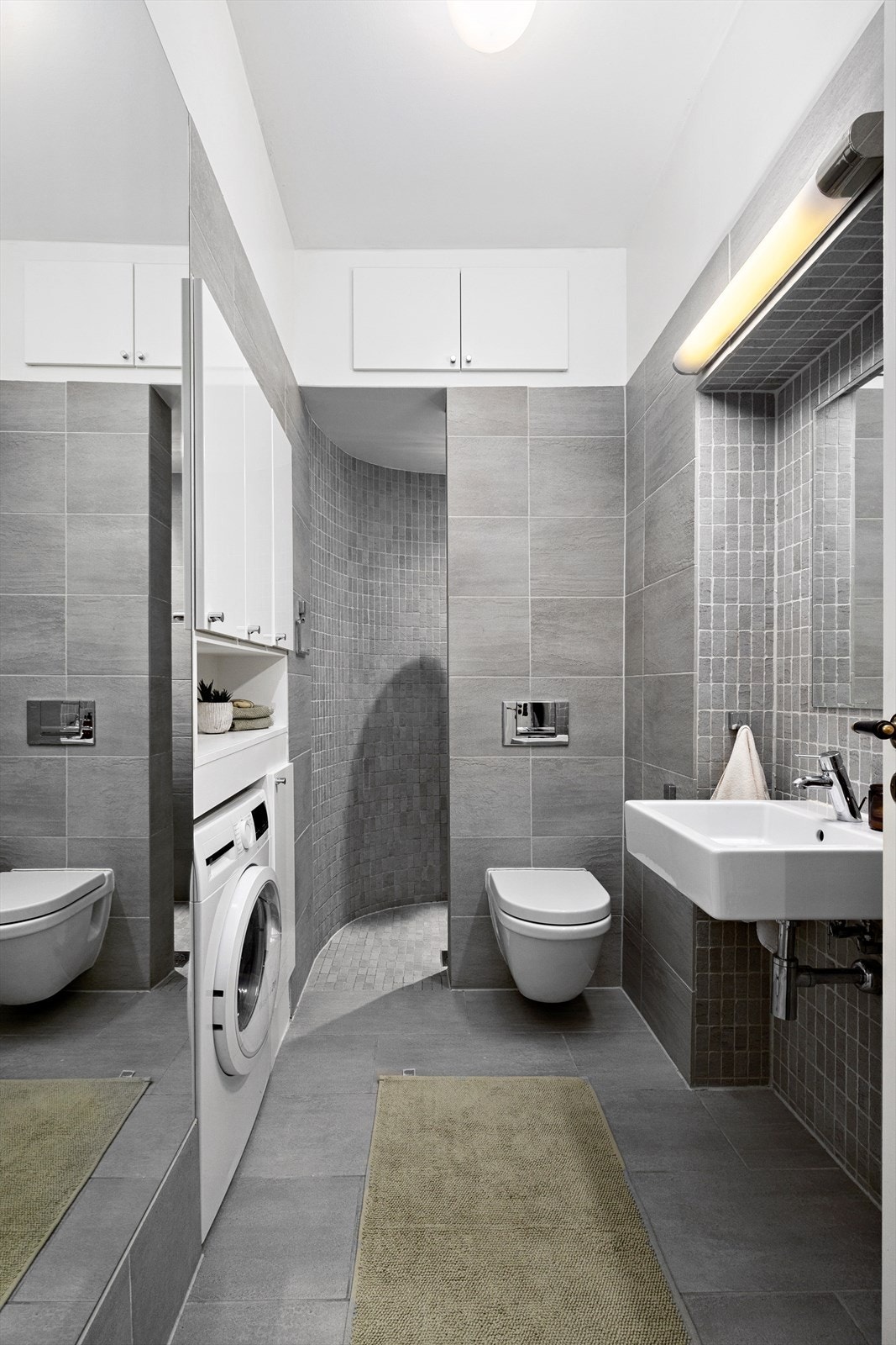 Flislagt bad med funksjonell innredning og god plassutnyttelse. Eget opplegg for vaskemaskin. Galleribilde