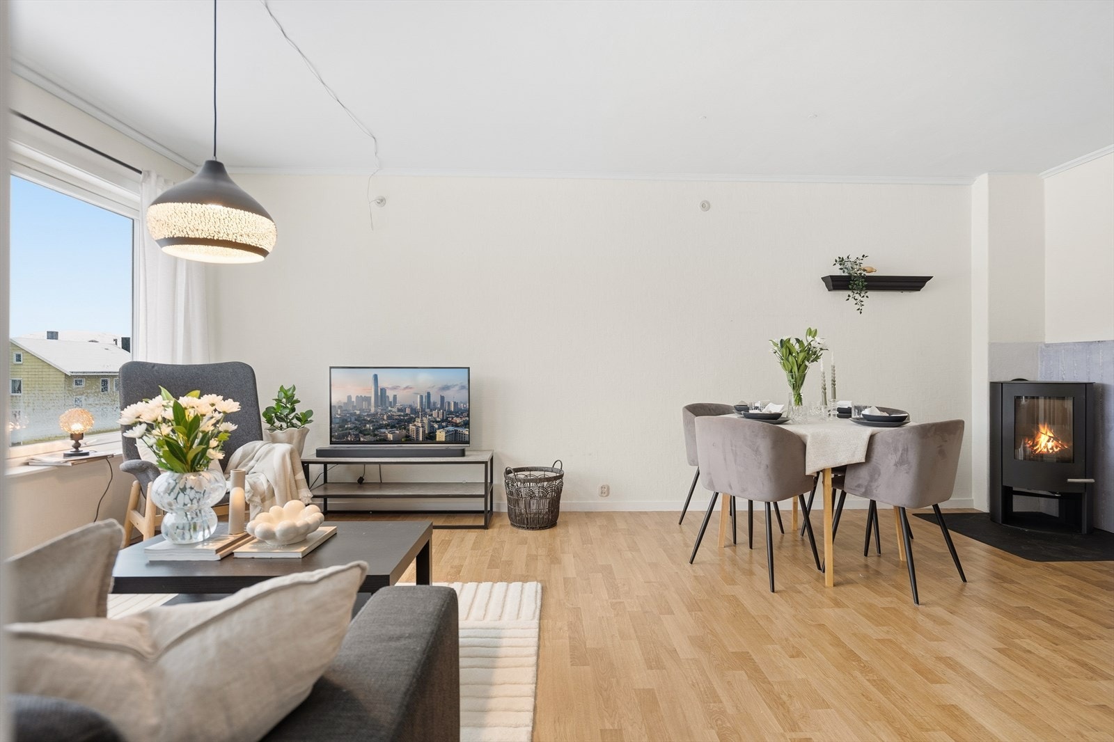 Romslig stue med plass for både sofa og spisebord. Vedovn gir leiligheten en lun og god varme. Galleribilde