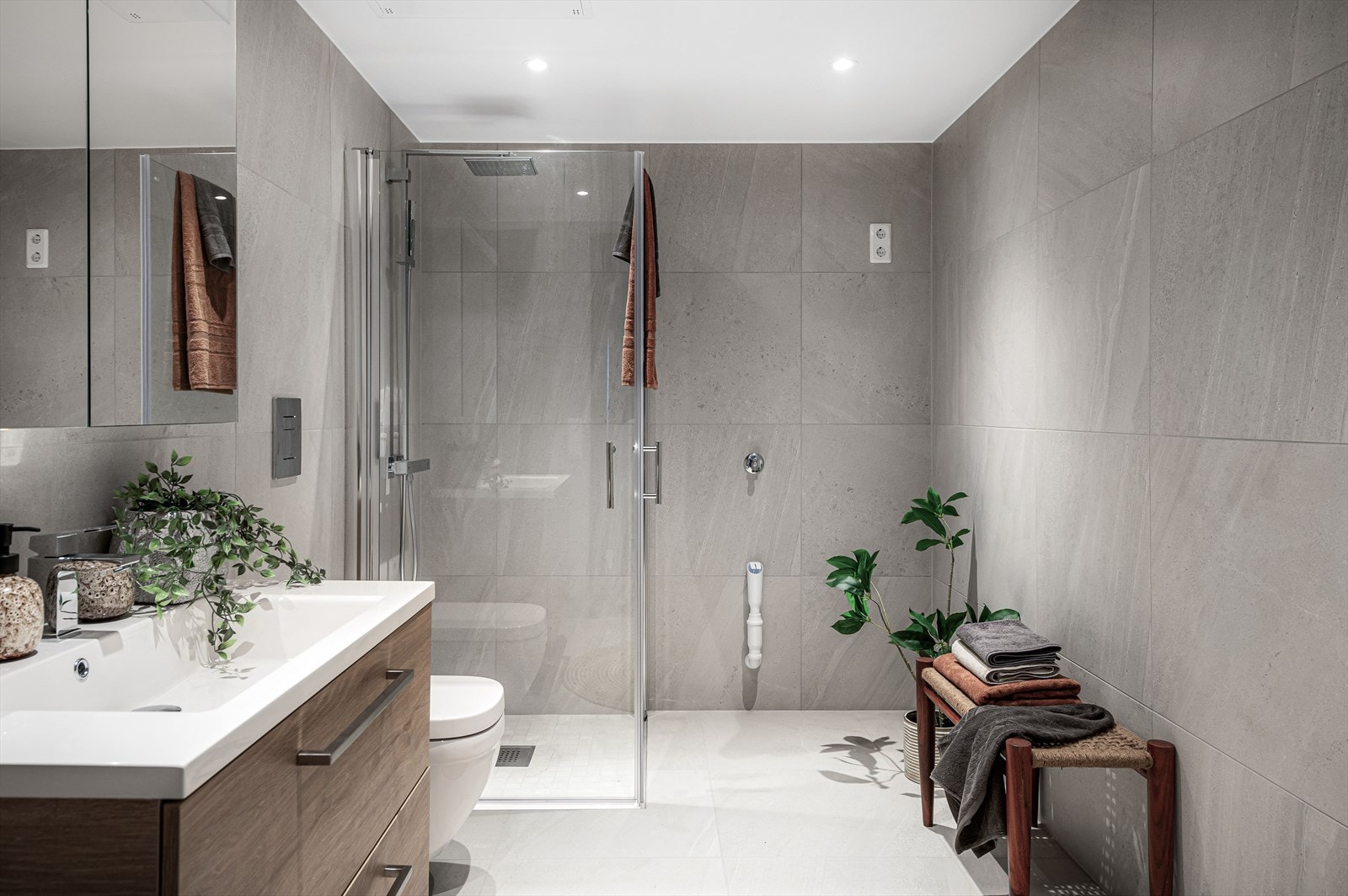 Baderom 1 med elektriske varmekabler i gulv og dimbare downlights i folierte metallplater i himling. Galleribilde