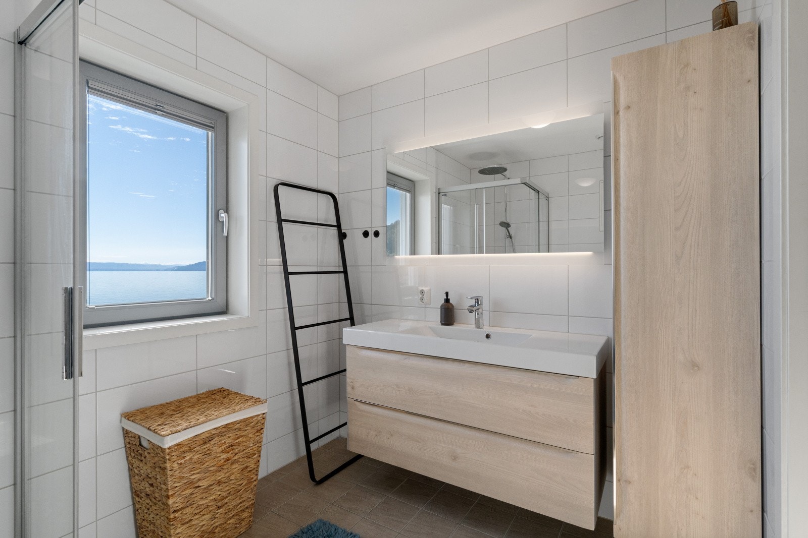 Delikat flislagt bad med dusj, vegghengt toalett og en lekker baderomsinnredning. Galleribilde