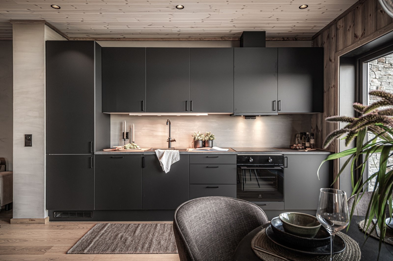 Stilren og praktisk Designa kjøkkeninnredning med en moderne løsning i dempet sort og med glatte dører og laminert benkeplate Galleribilde