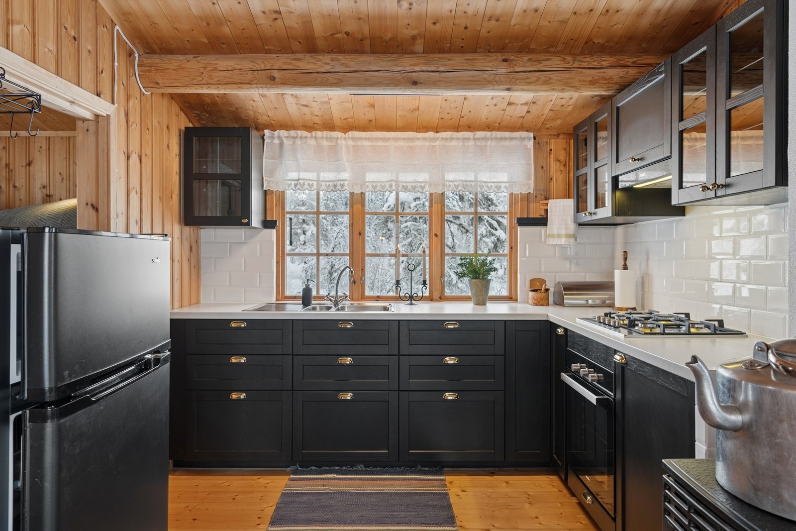 Kjøkkenet er innredet med gassdrevet integrert komfyr og koketopp, dobbel utslagsvask, fliser mellombenkeplate og overskap Galleribilde