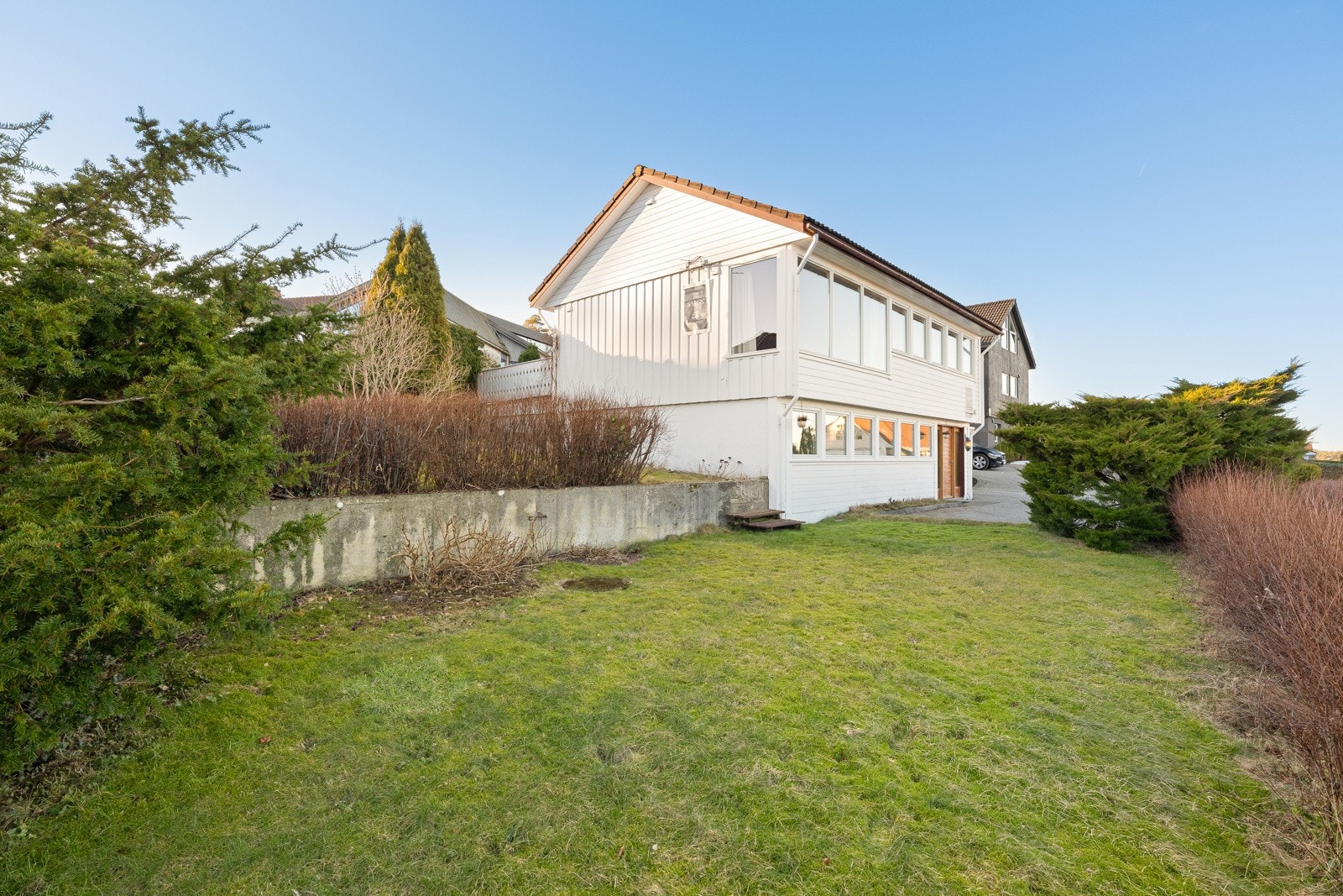 Uteområdet er pent og gjennomført opparbeidet med grønne arealer som skaper en innbydende og harmonisk ramme rundt boligen Galleribilde