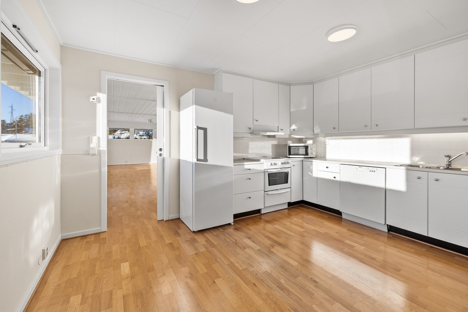 Kjøkkenet er romslig og praktisk plassert i eget rom i tilknytning til stuen, noe som gir en fin balanse mellom åpenhet og avskjerming. Skyvedør mellom rommene gjør det enkelt å åpne opp ved behov. Galleribilde