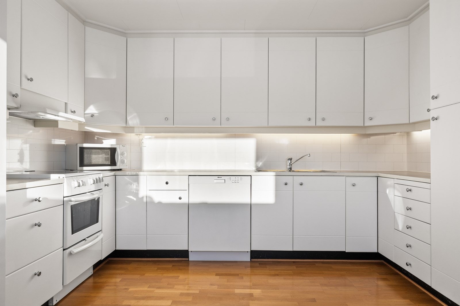 Innredningen er fra Huseby og har glatte fronter som gir et stilrent og tidløst uttrykk. Den rene utformingen gjør kjøkkenet enkelt å kombinere med ulike interiørstiler, og skaper et ryddig og helhetlig preg. Galleribilde