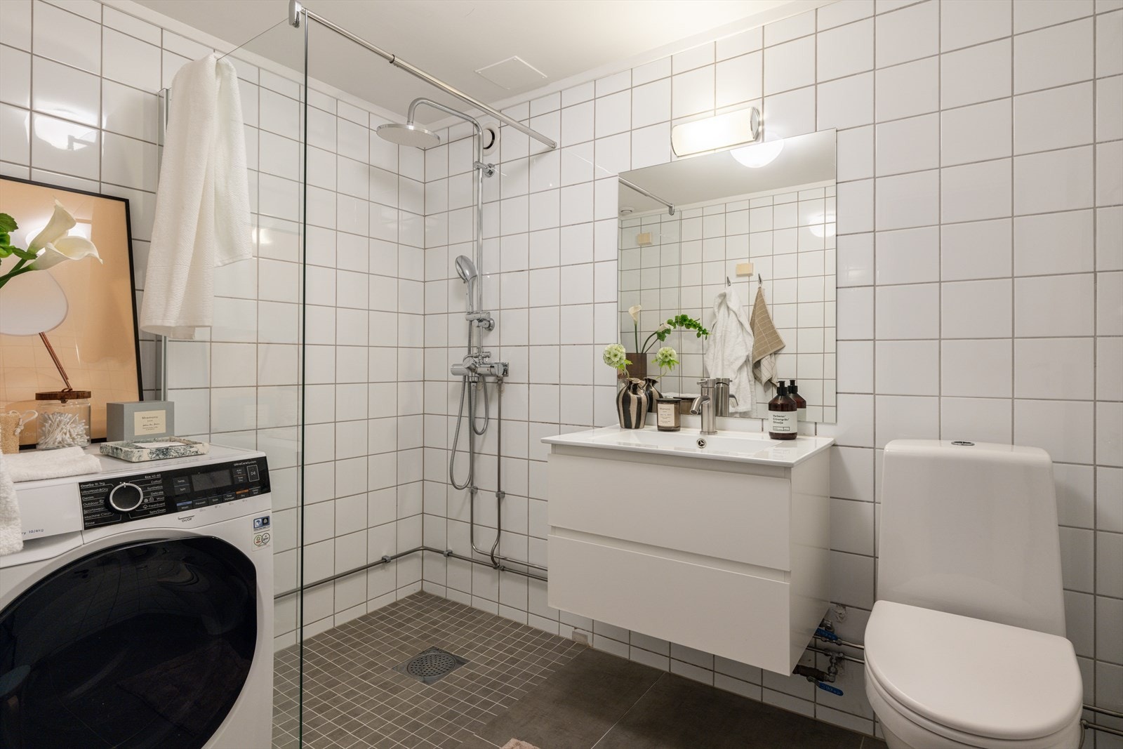 Romslig flislagt bad med behagelig gulvvarme og opplegg for vaskemaskin. Galleribilde