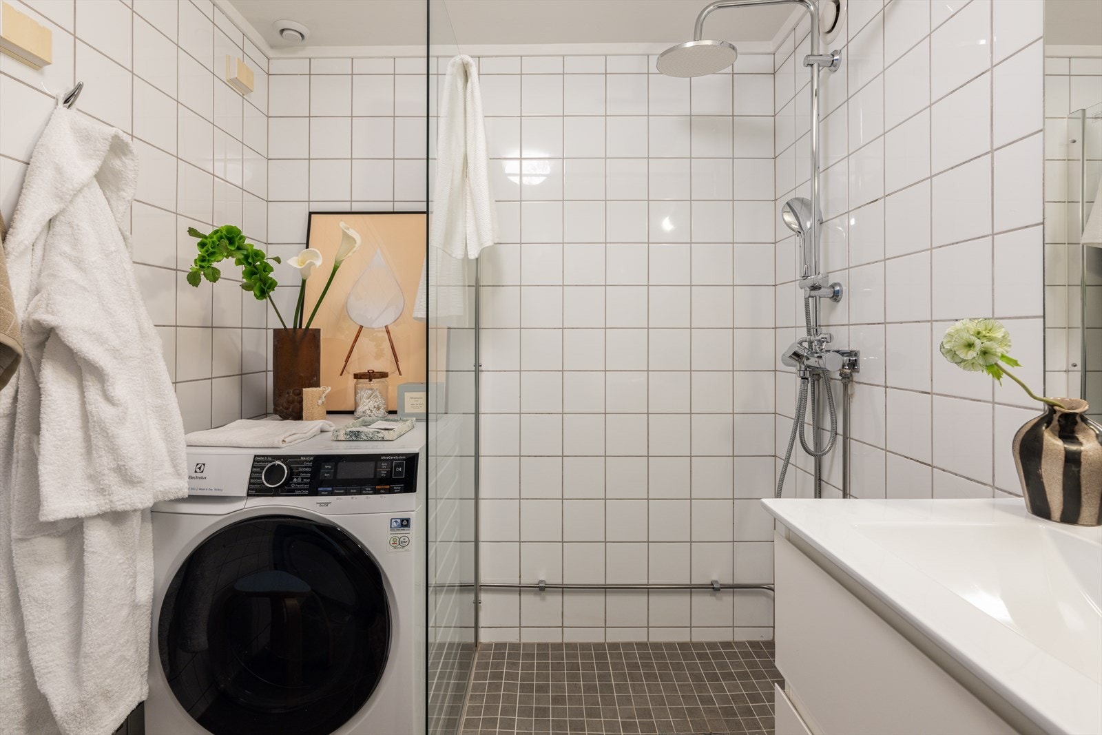 Badet er innredet med servantskap med skuffeseksjon, speil, vegghengt toalett og dusjhjørne. Galleribilde