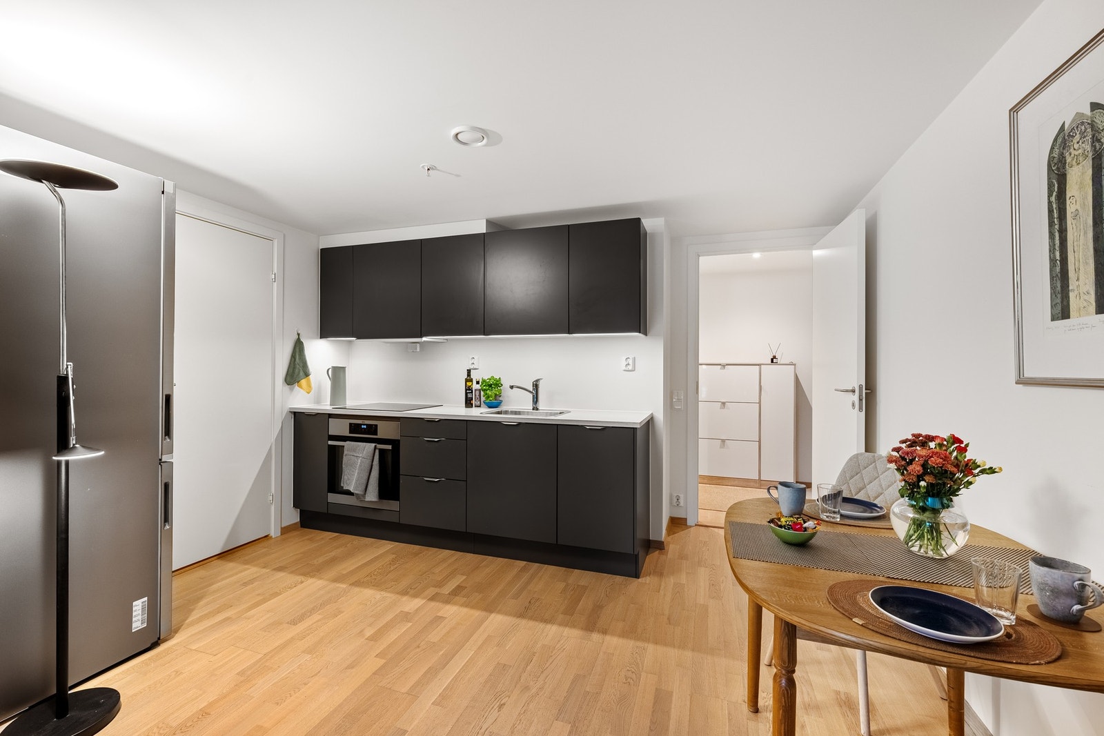 Kjøkkenet er innredet med slette fronter og en slitesterk laminert benkeplate. Galleribilde