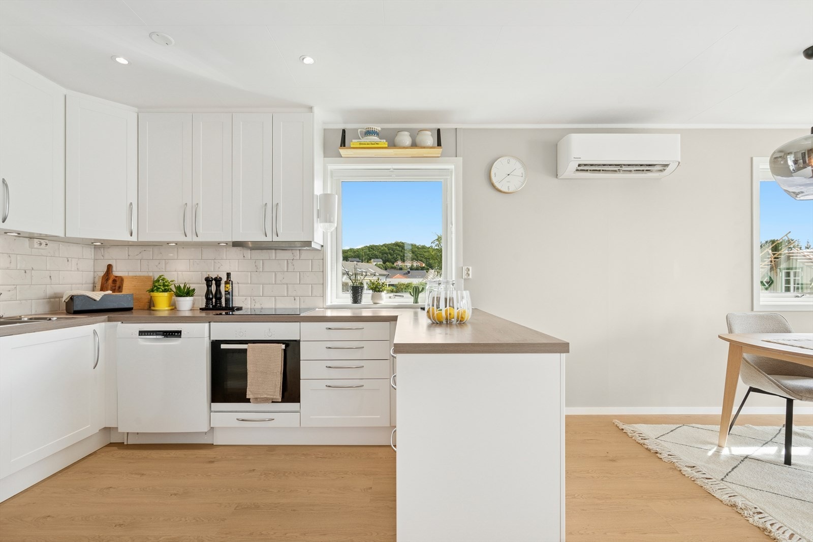 Lyst og moderne kjøkken med mye skap- og benkeplass Galleribilde