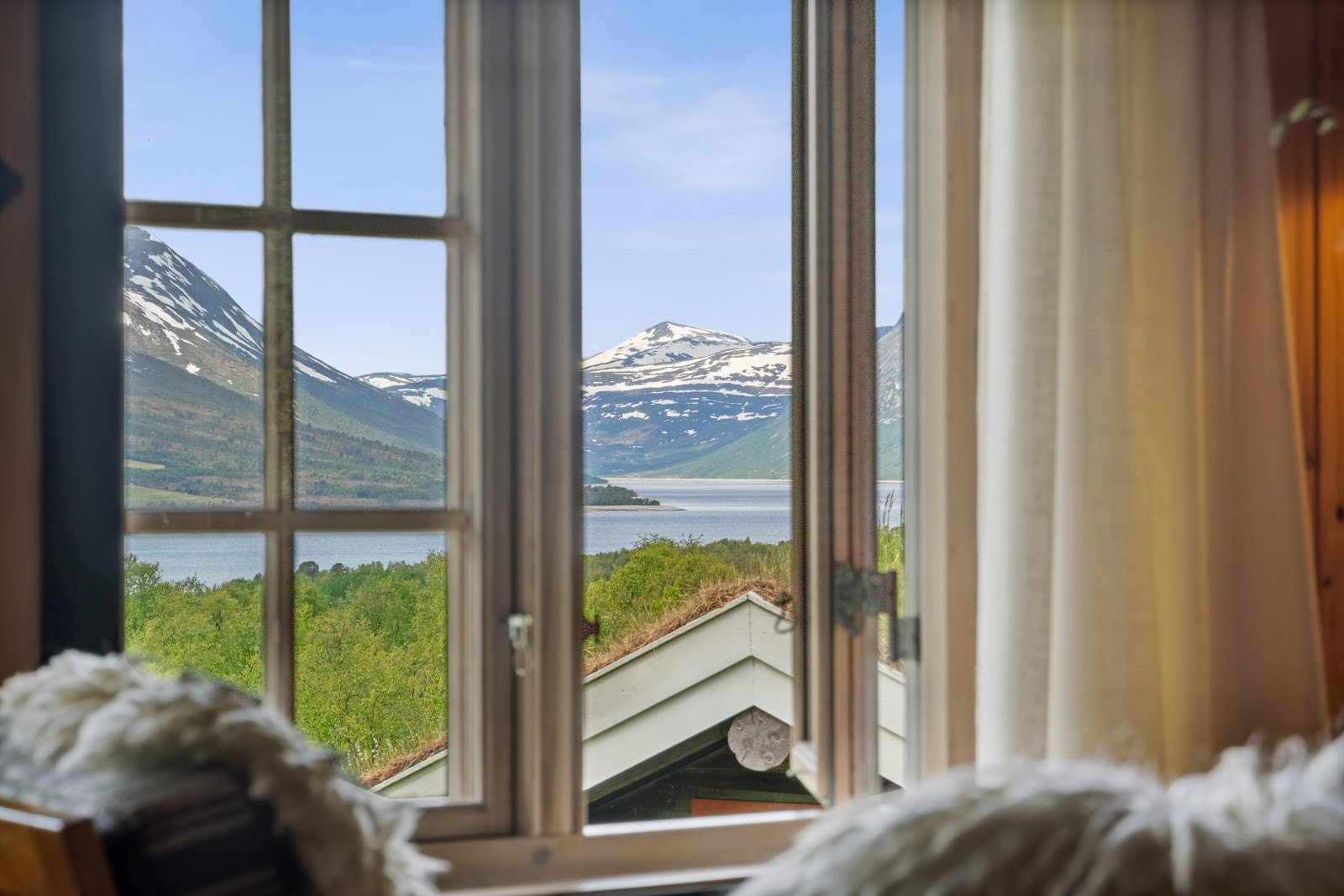 Utsikten er slående vakker, til vann, fjell og det nydelige, grønnkledde landskapet rundt. Galleribilde