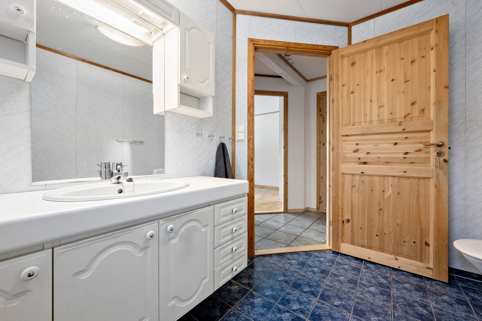 Badet er innreidd med klosett, badekar med dusjarmatur og servant i underskap Galleribilde