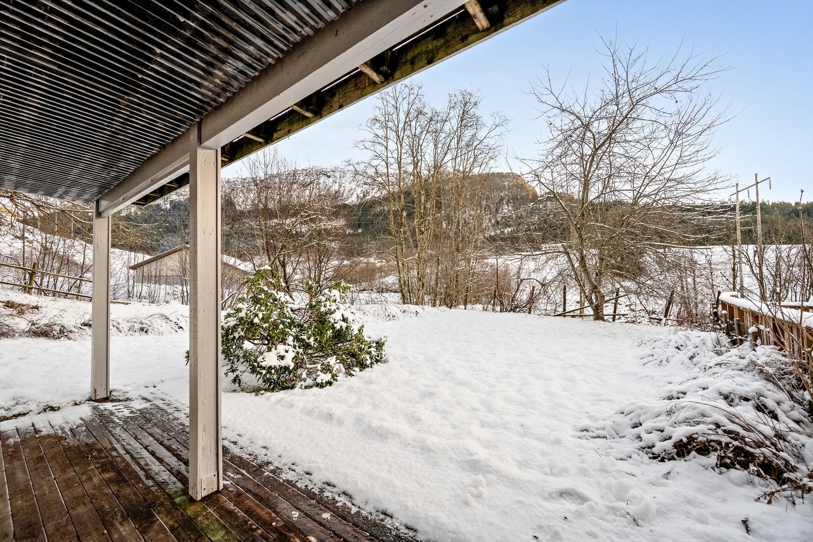 Uteområde med flatt plenareal og dels overbygd platting Galleribilde