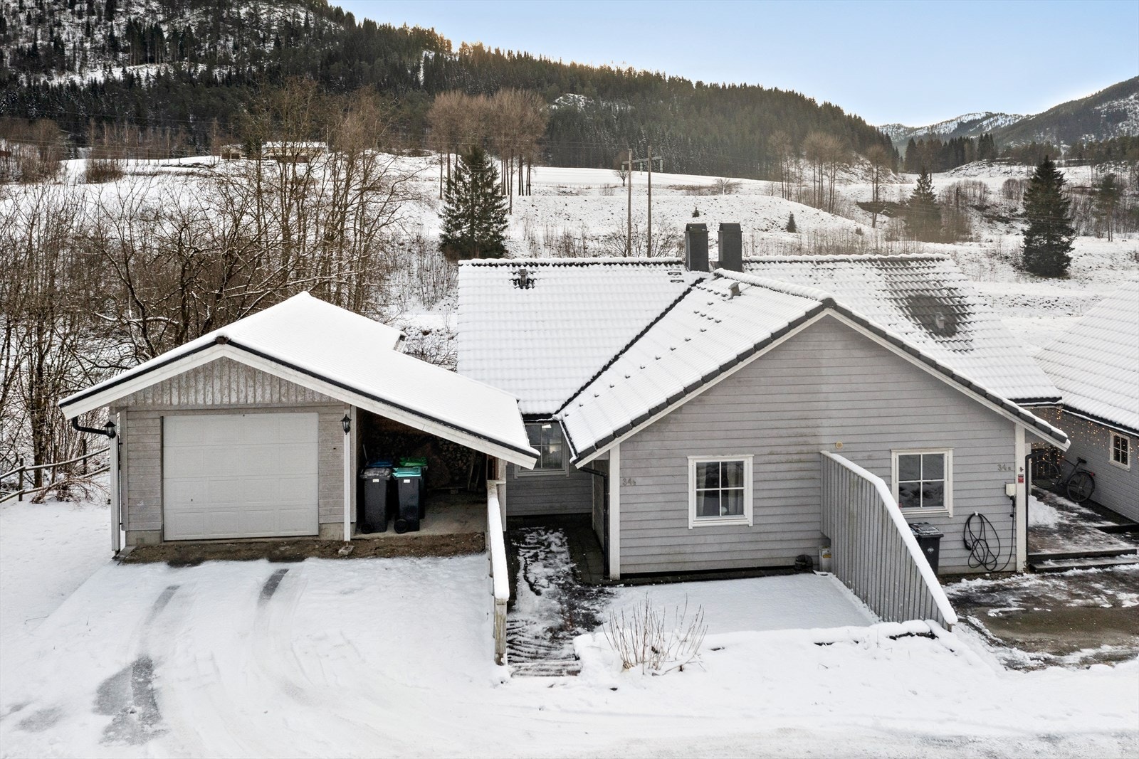 Ved bustaden er det oppført ein garasje med elbilladar og carport Galleribilde