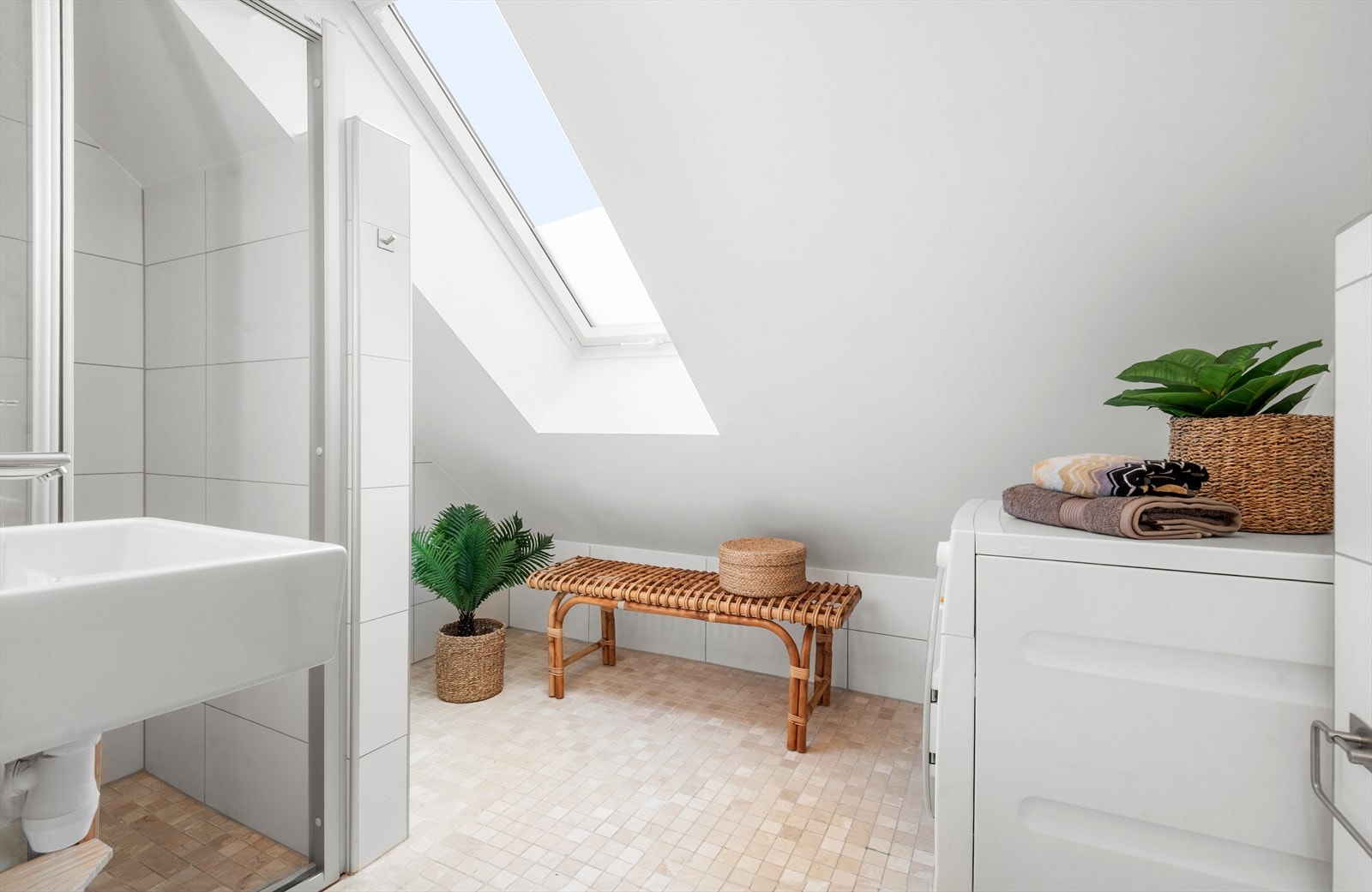 Badet er innredet med faste felt og dør i herdet glass, servant, veggfestet klosett med innebygget
sisterne, samt opplegg for vaskemaskin Galleribilde