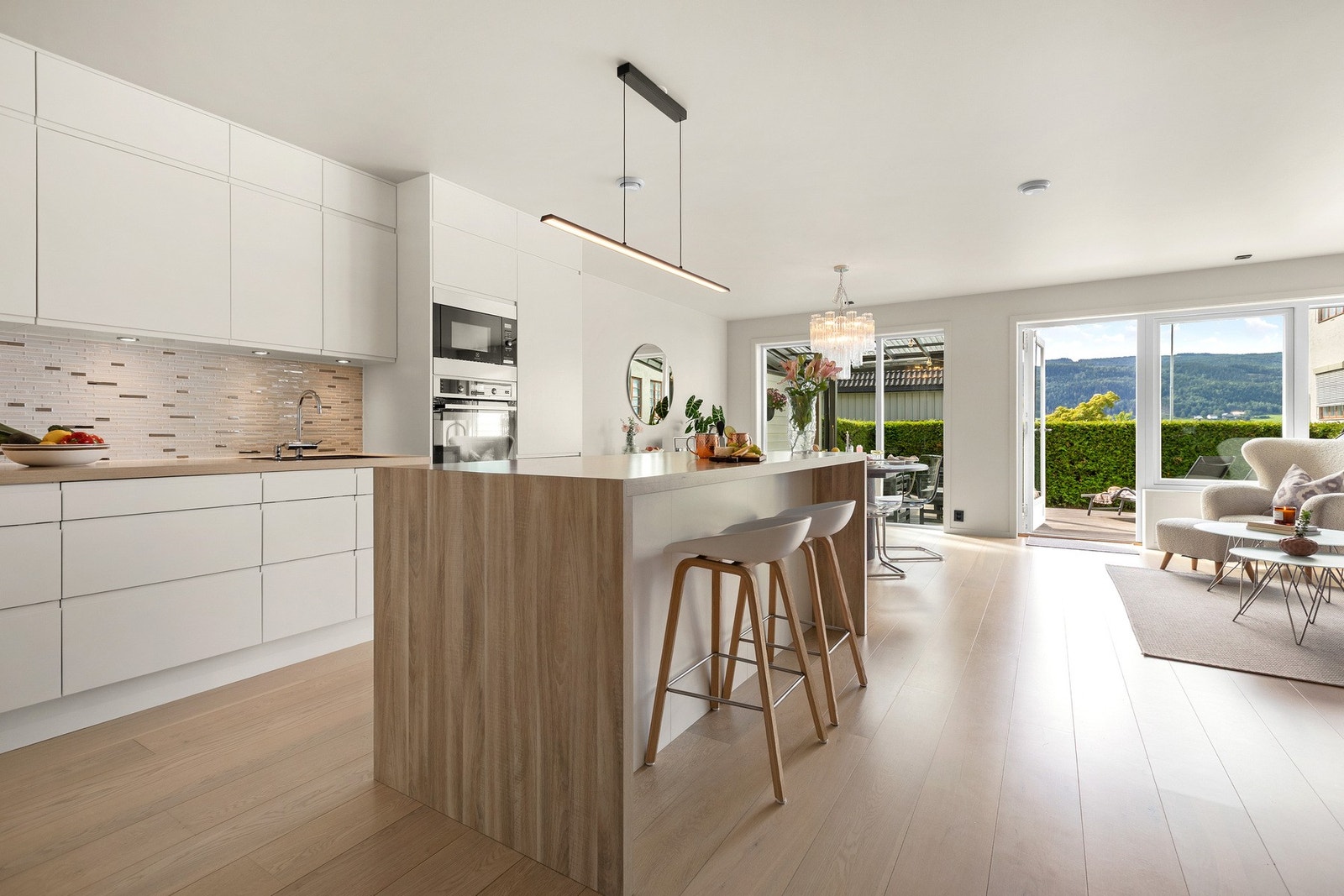 Moderne kjøkken med barløsning som knytter sammen matlaging og sosialt samvær - perfekt for både hverdagsbruk og gjester. Galleribilde