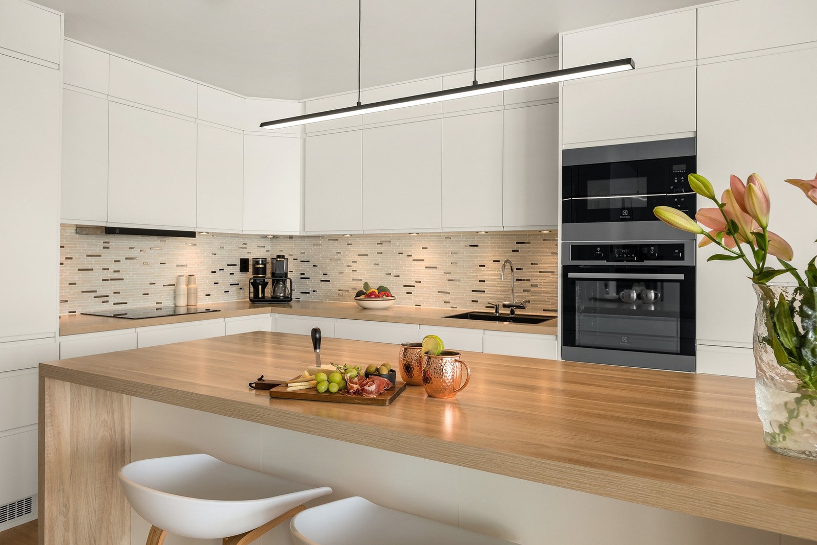 Stilrent kjøkken med tidløse, hvite fronter, integrerte hvitevarer og godt med arbeidsplass. Galleribilde