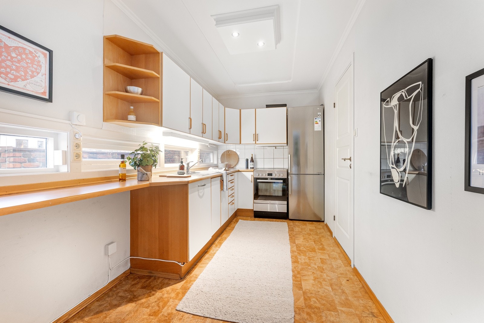 Eldre kjøkken med glatte fronter og laminat benkeplate med nedfelt oppvaskkum. Galleribilde