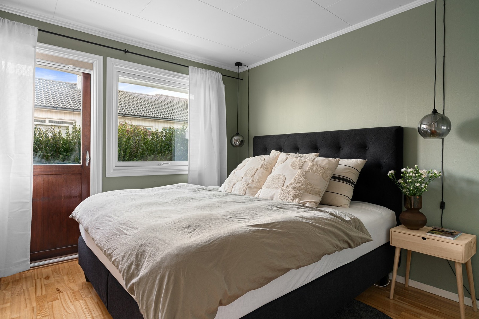 Hovedsoverommet i første etasje har parkett på gulvet, moderne grønntone på veggene og garderobeskap langs den ene veggen. Galleribilde